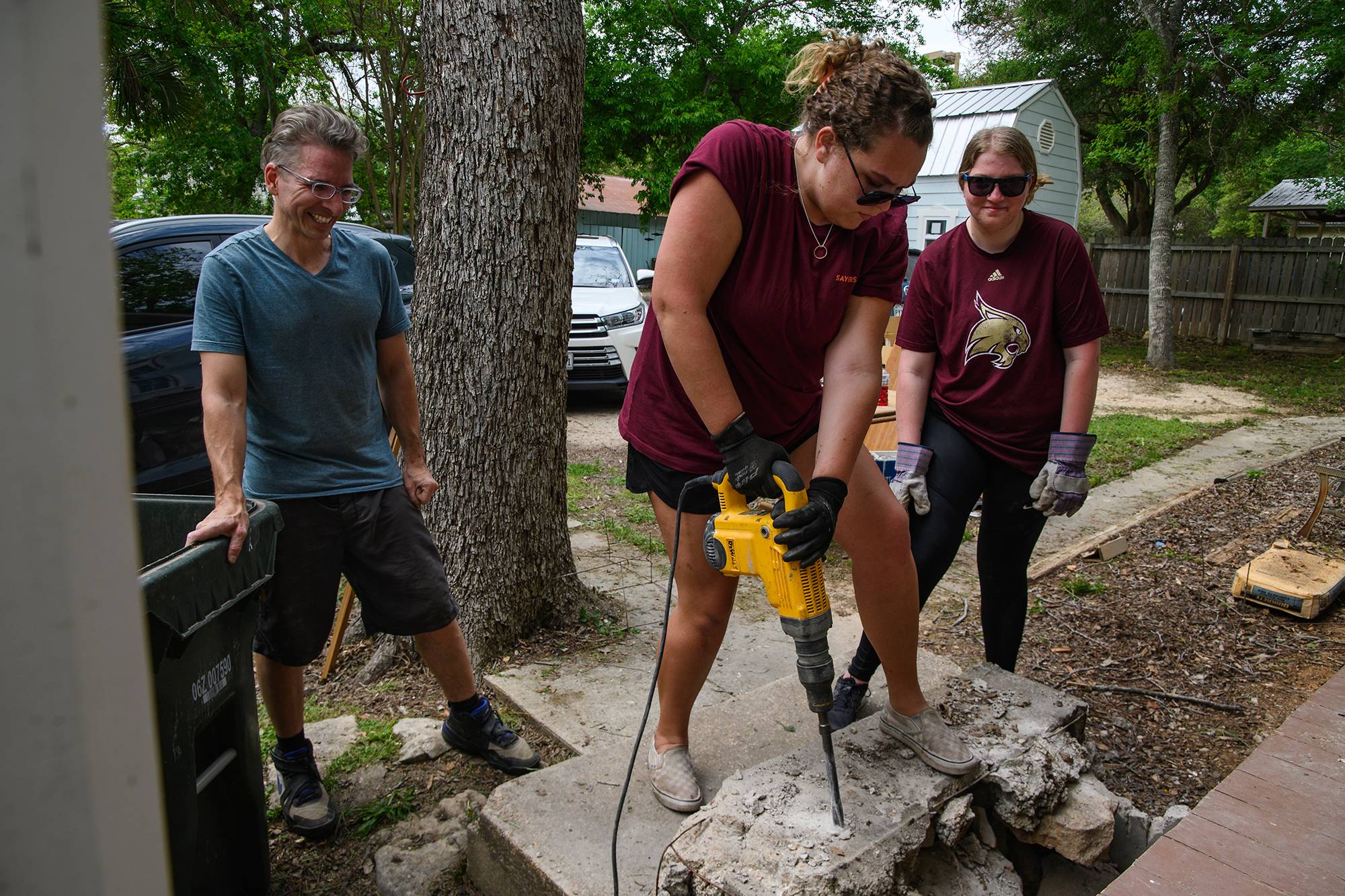 Students working with a jackhammer on a community service project