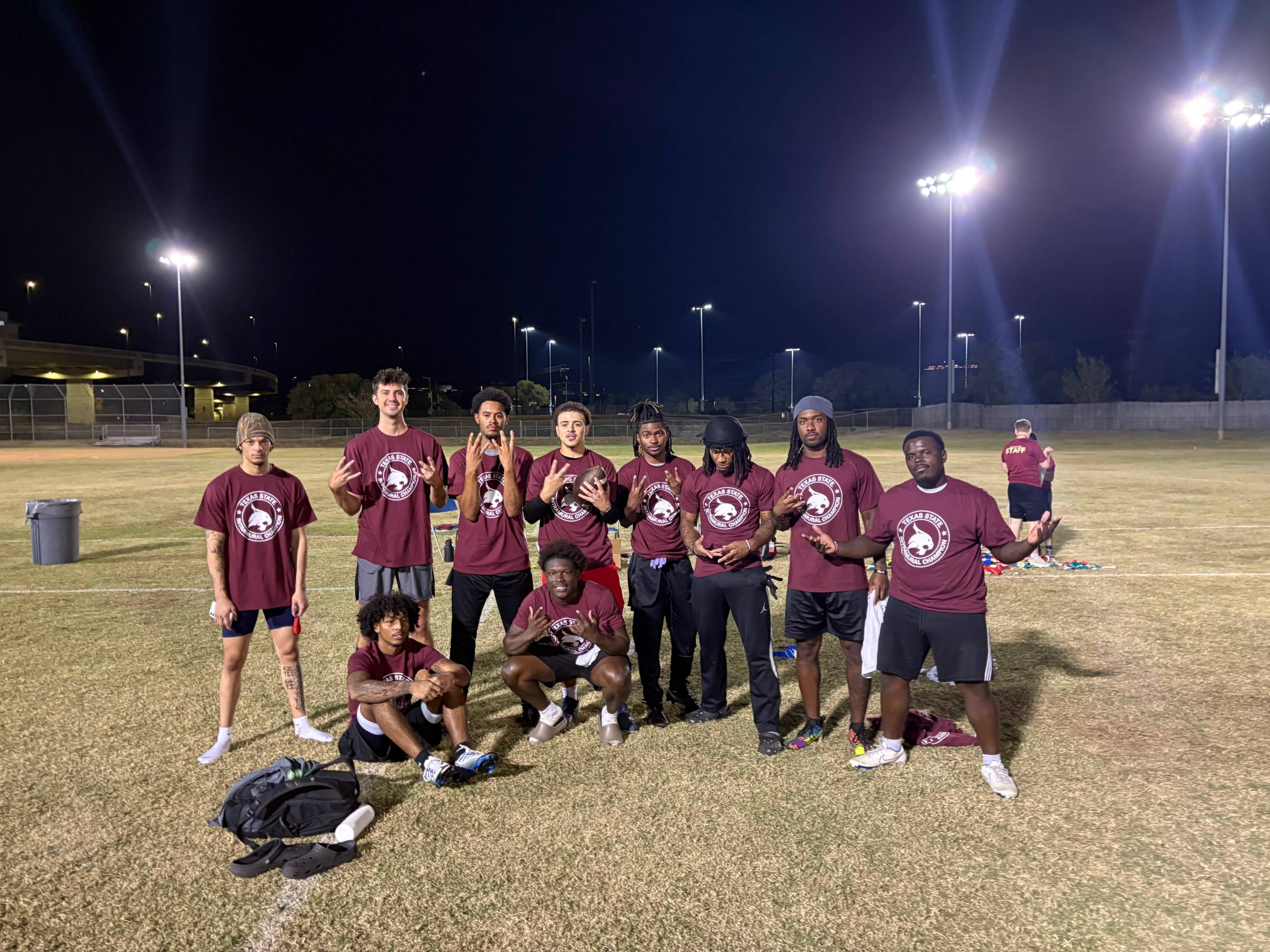 Fall 2025 Flag Football Men's A Champions posing for picture with champion shirts