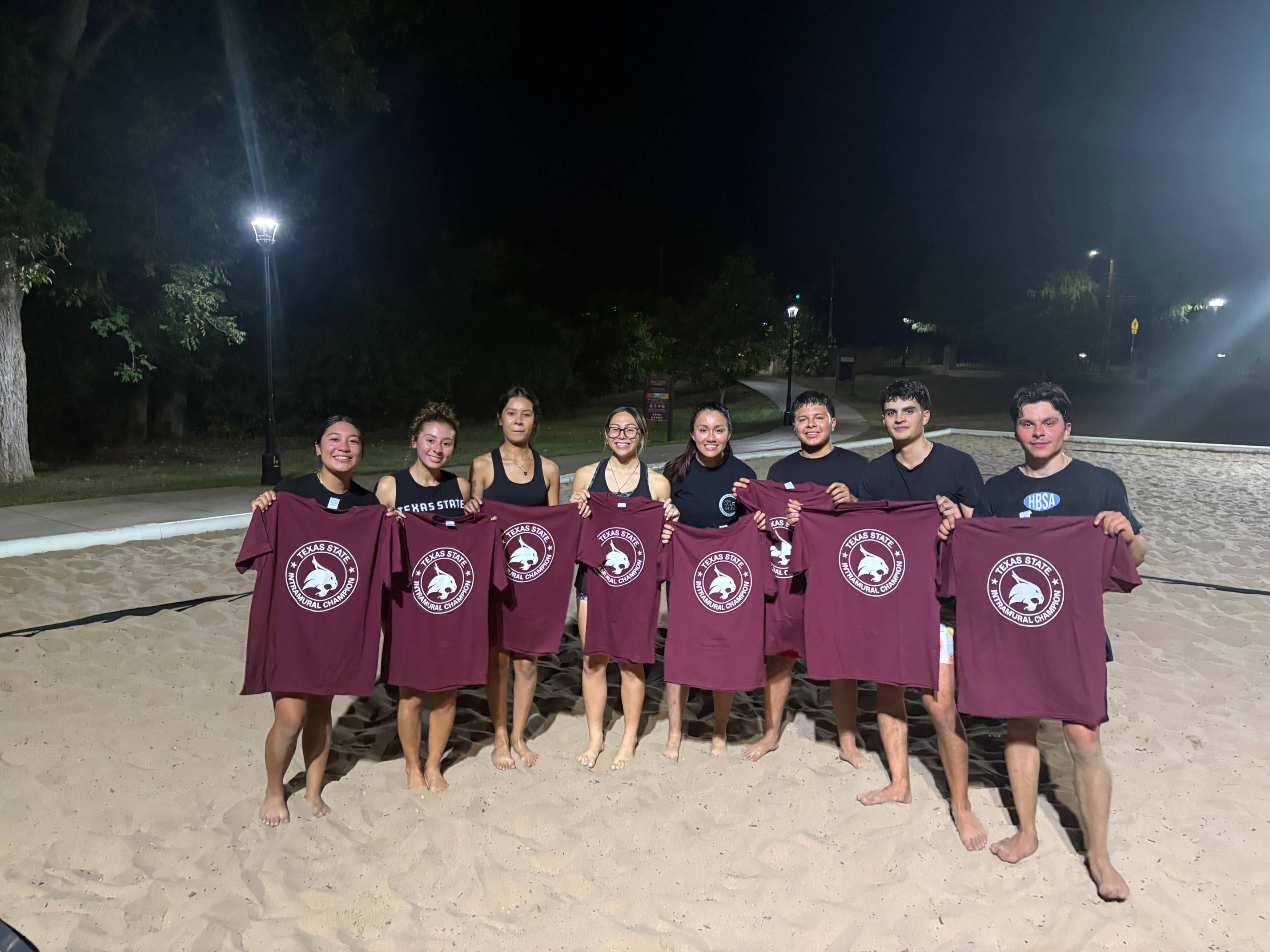 Fall 2025 CoRec Sand Volleyball Champions posing for a picture with champ t-shirts