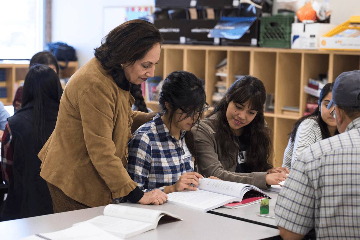 A professor guiding a student in class.