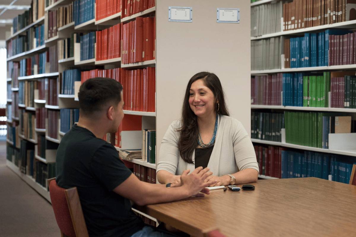 A professor guiding a student in the classroom