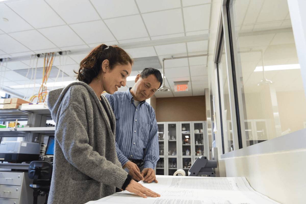 A professor guiding a student in the classroom