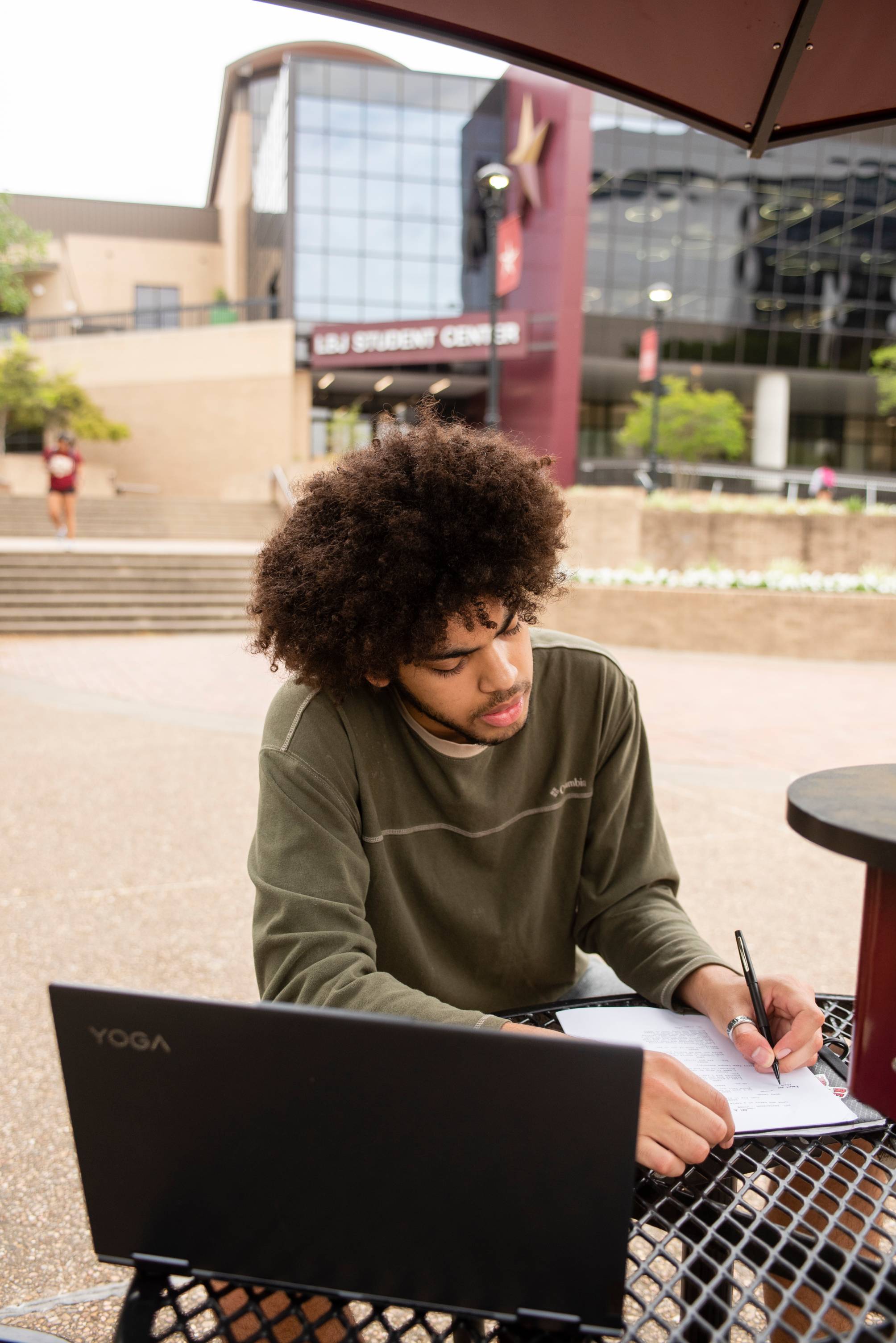 Person using laptop and notebook.
