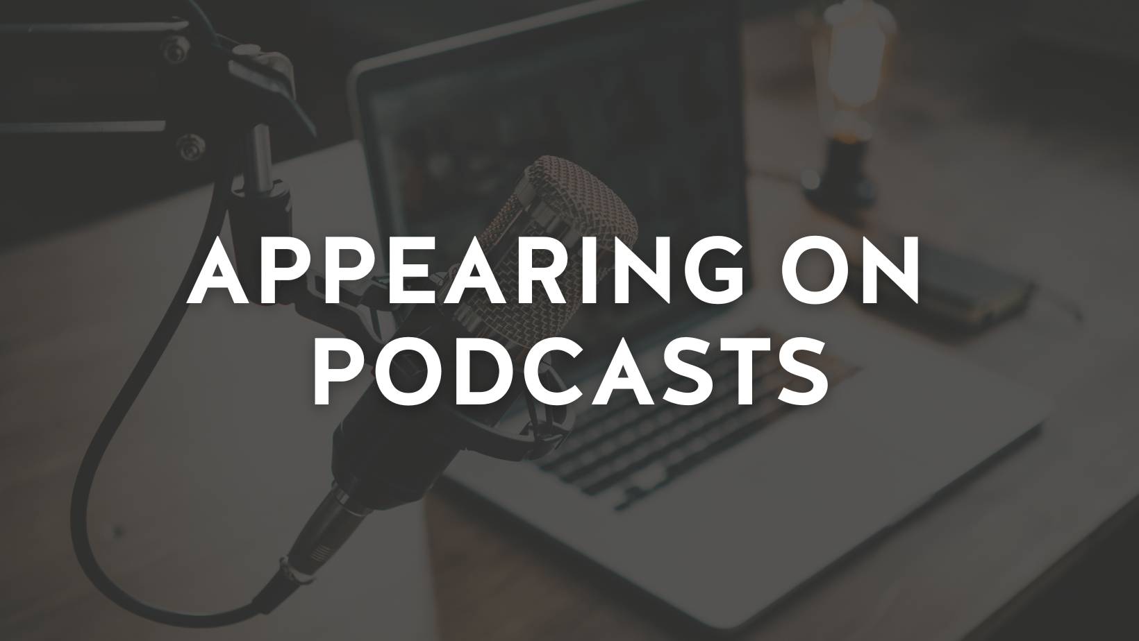 A podcast microphone and a laptop sitting on a desk. Overlayed text reads, "Appearing on Podcasts"