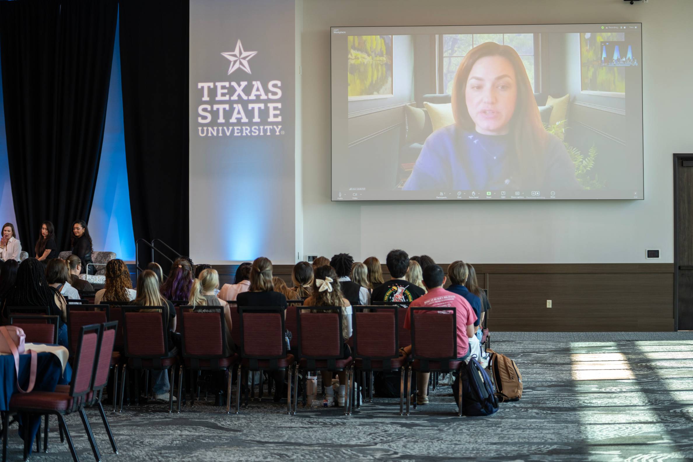 Zoom speak on screen in front of students.
