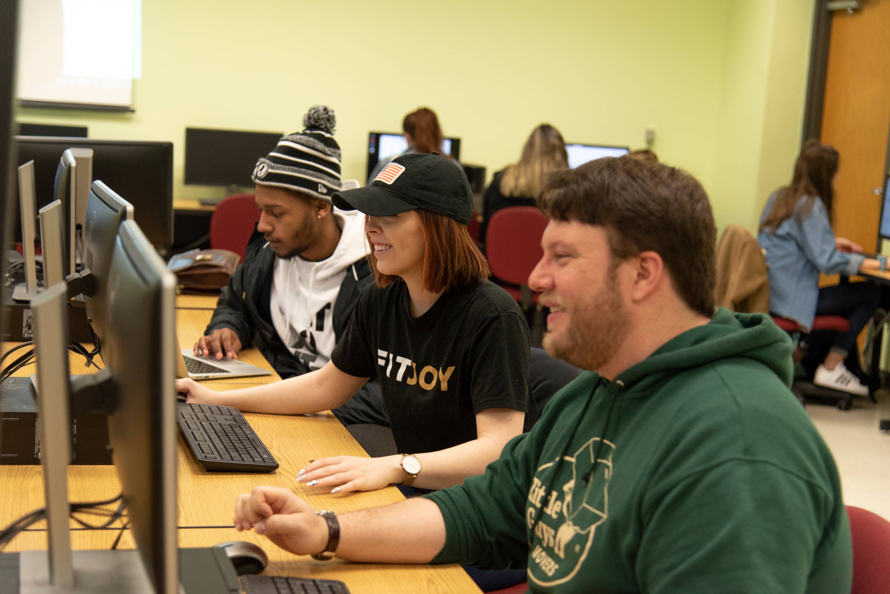 Smiling students in a computer lab.