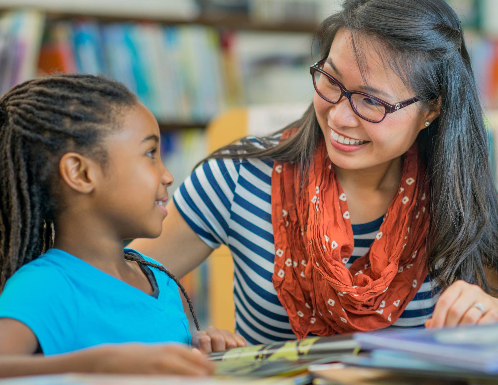 a woman sitting next to a student