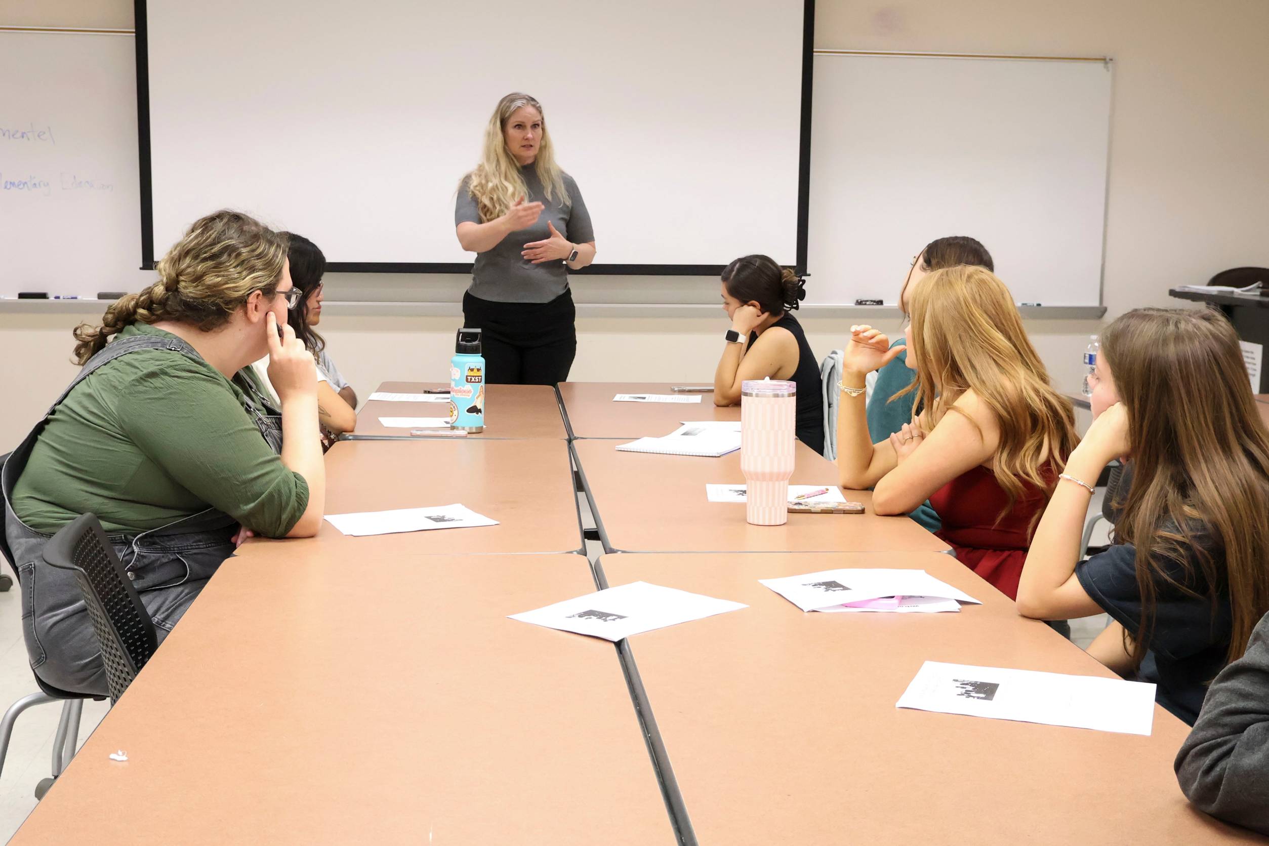 classroom with one woman standing in front of students