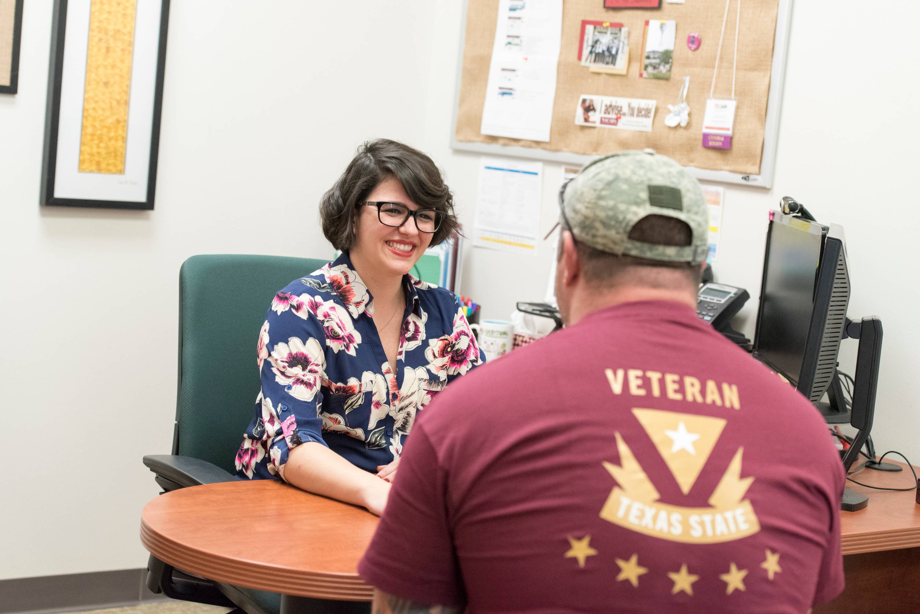 veterans walking on a college campus holding flags