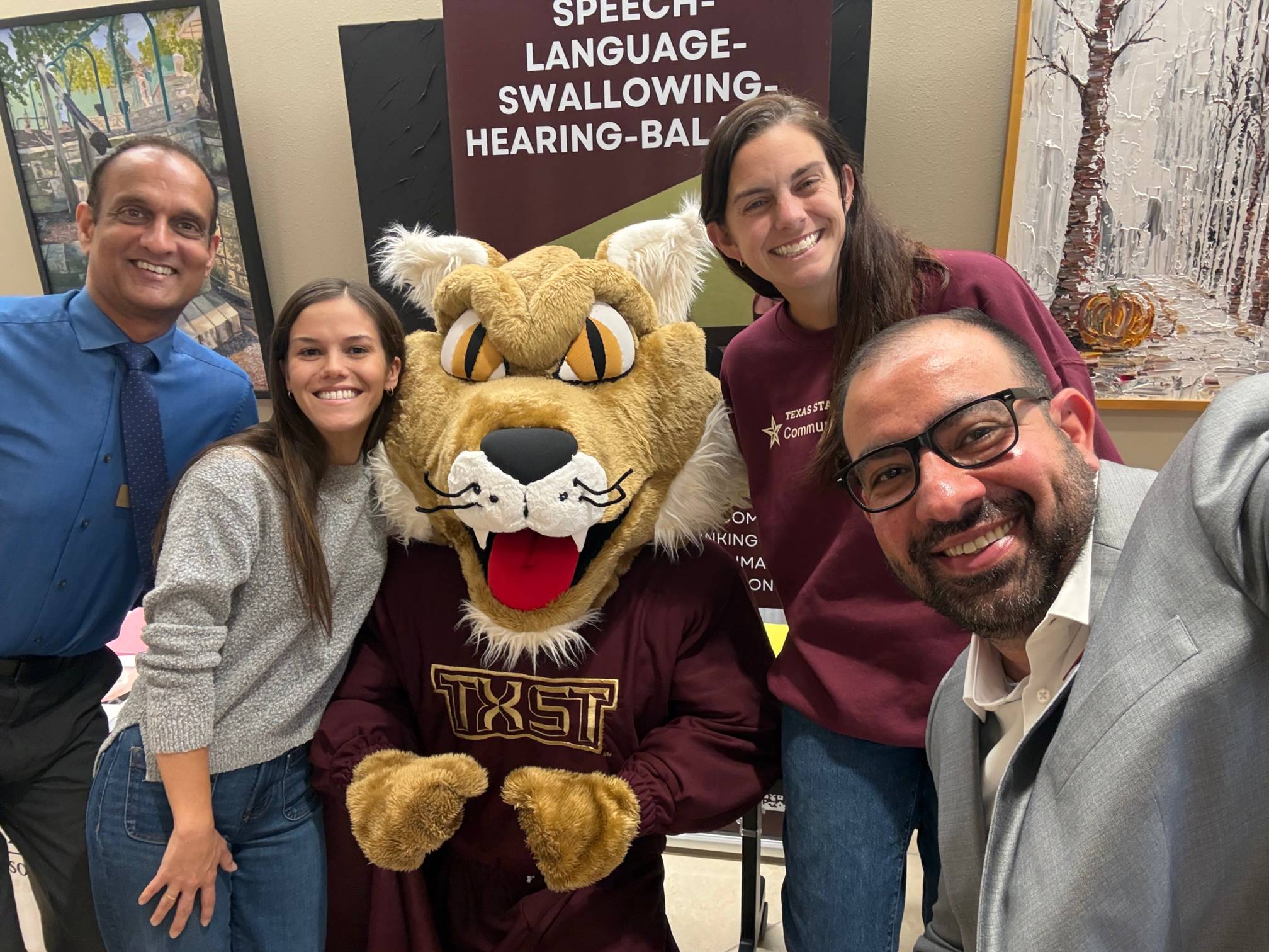 Dr. Irani, Dr. Ramanathan and 2 CDIS students posing next to Boko the Bobcat!