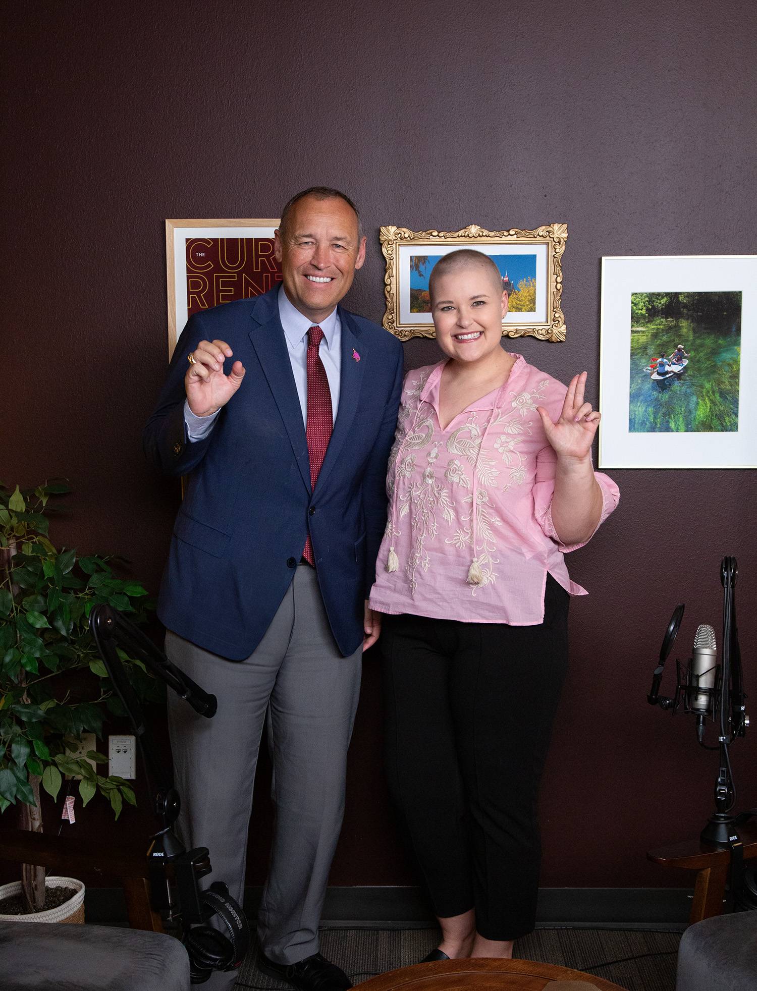 man and woman pose for a photo while holding up the txst hand signs.