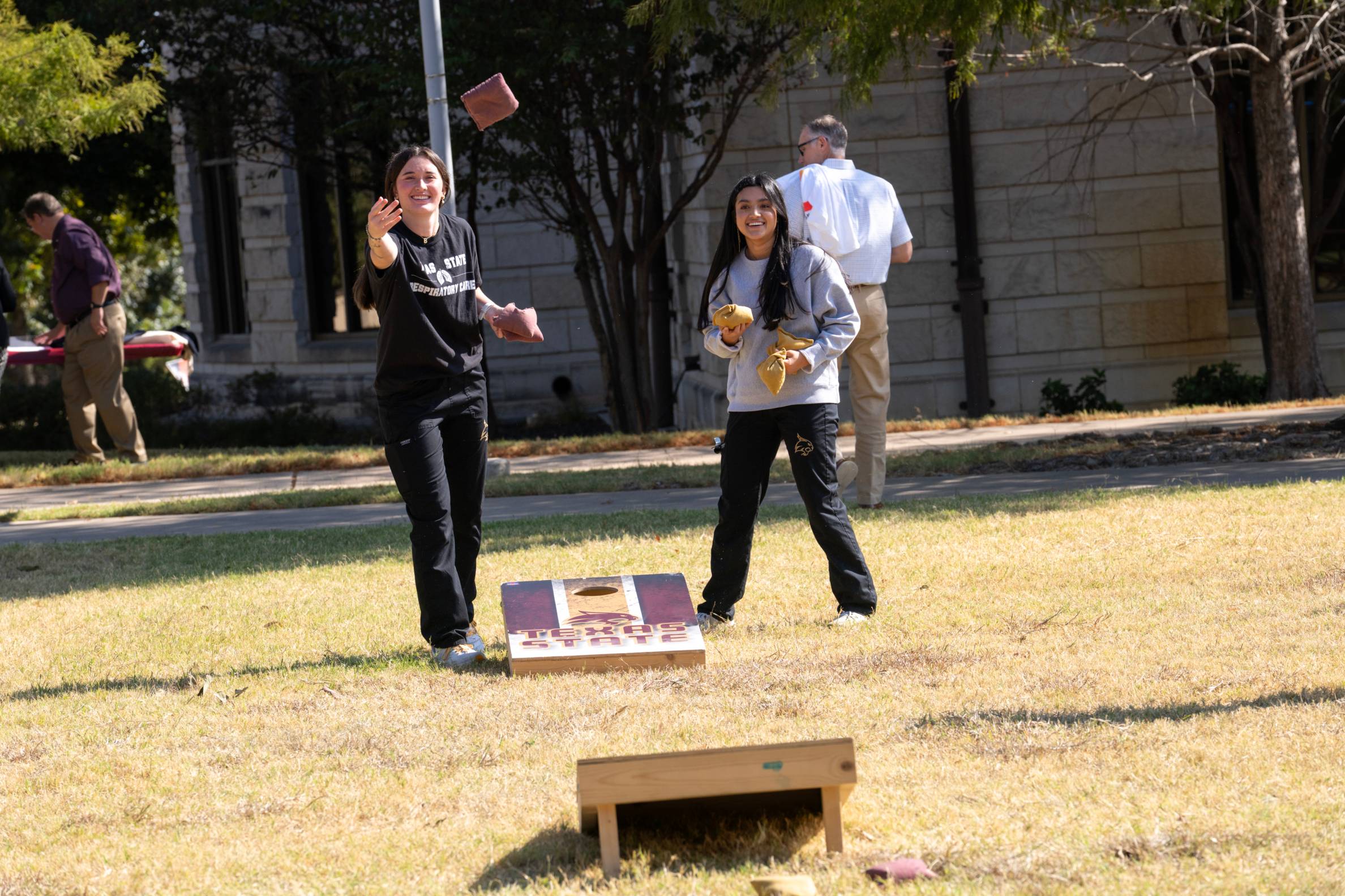 two students playing cornhole