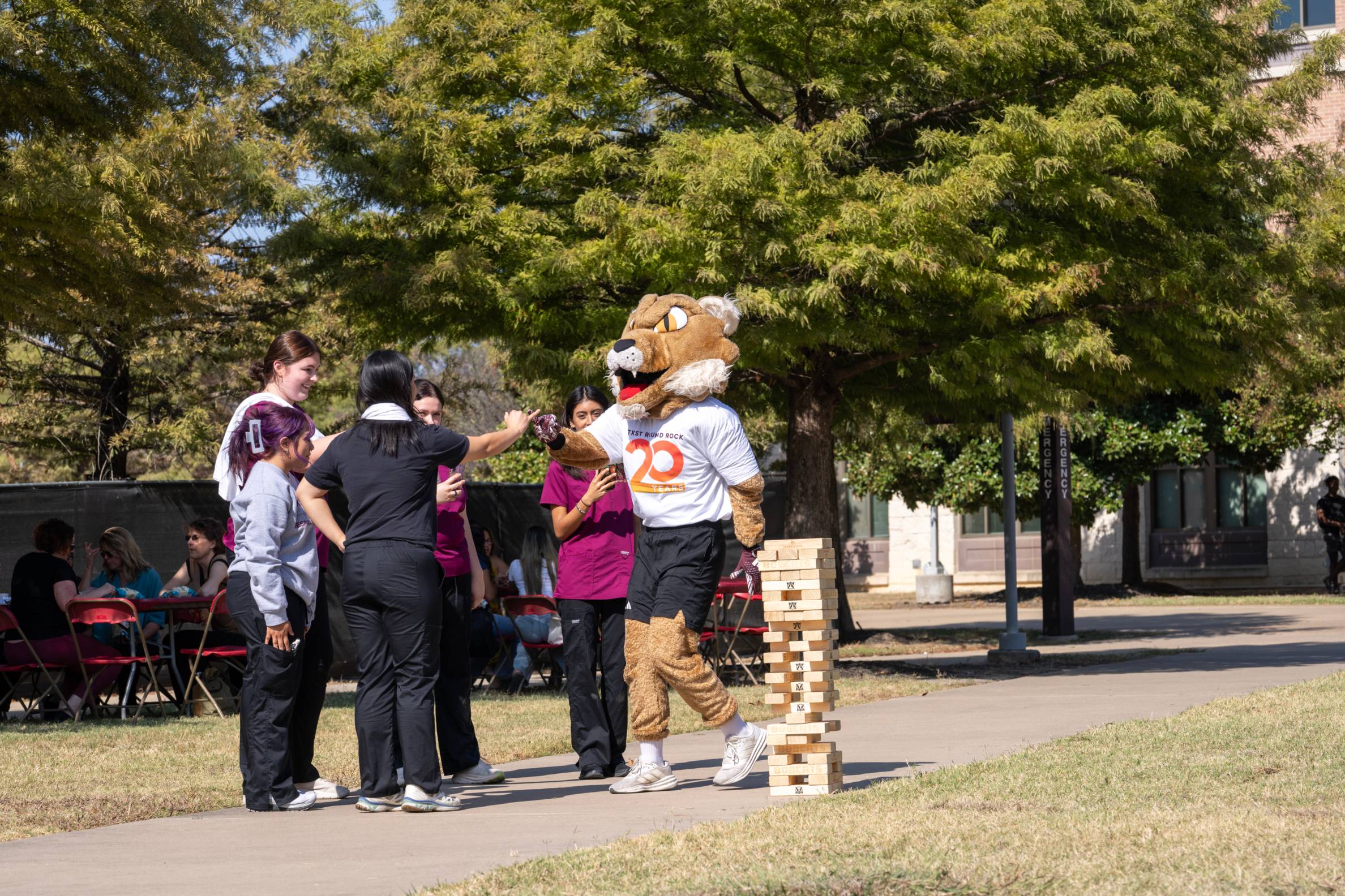 Bobcat playing jenga with students