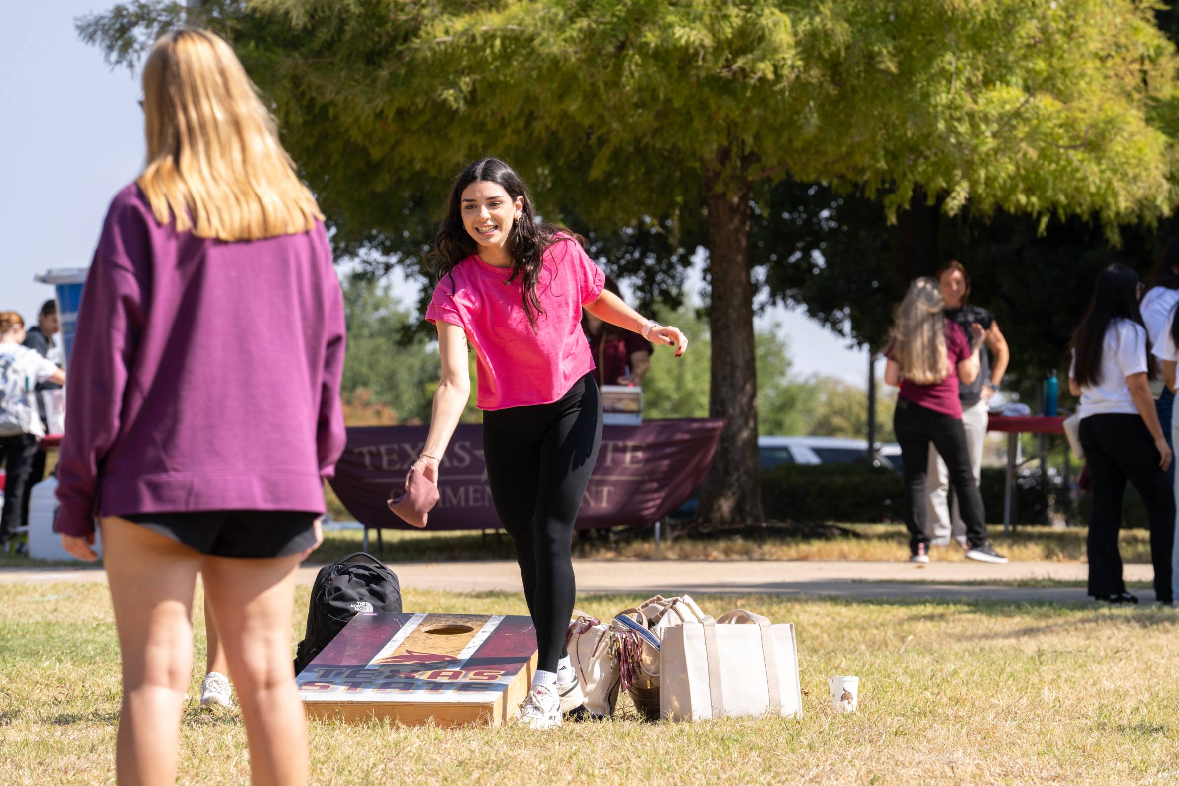 students playing a cornhole