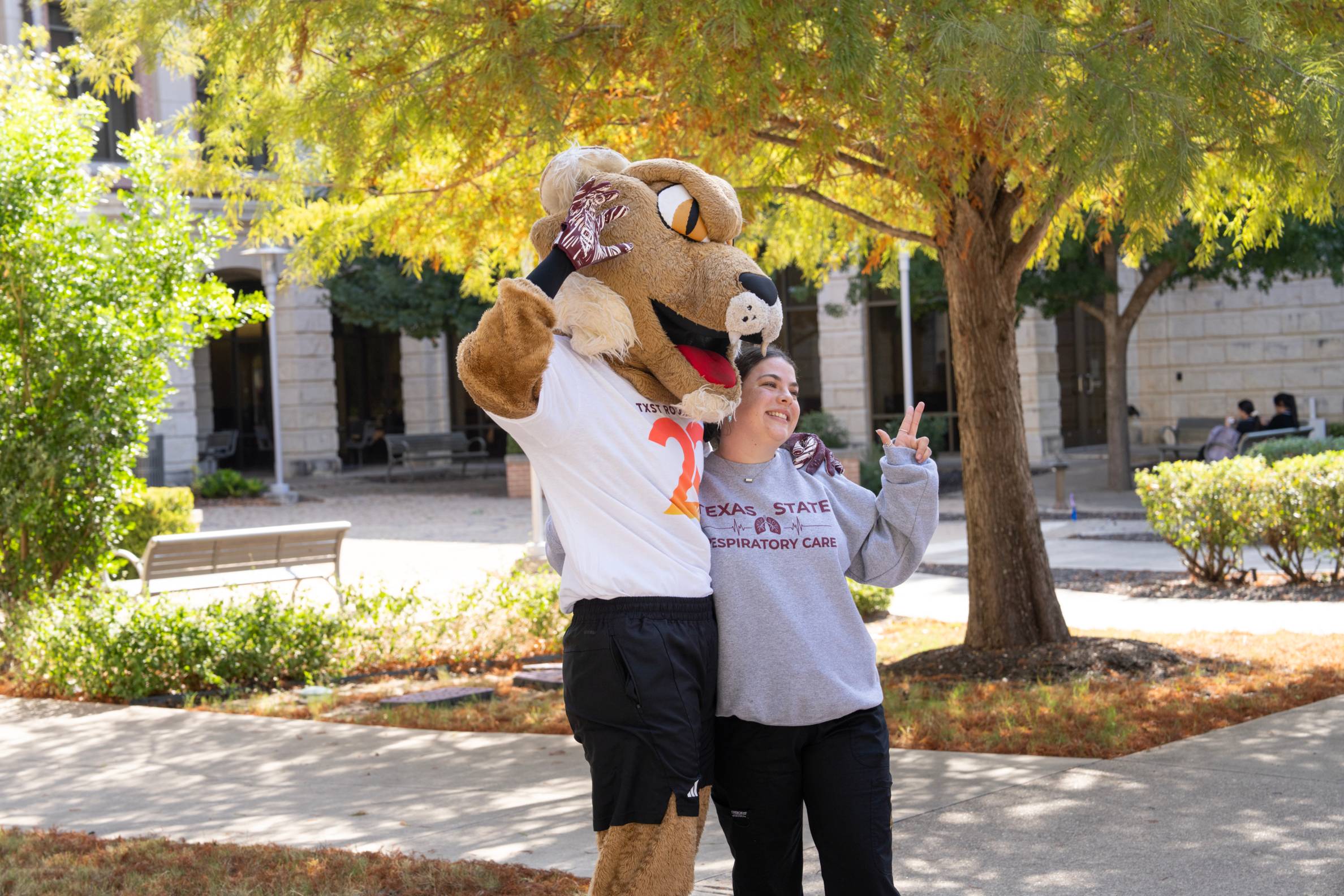 bobcat taking a picture with a student