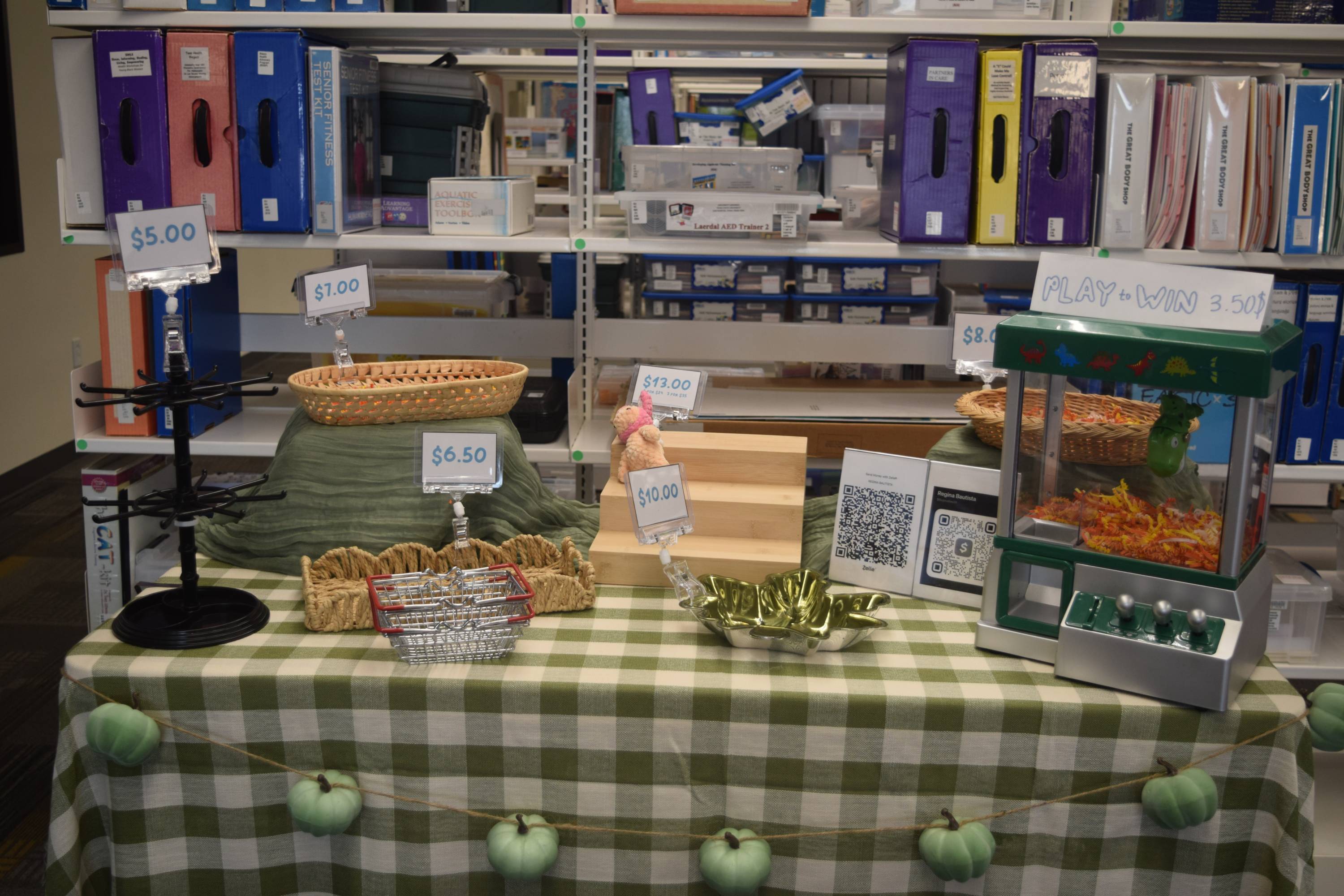 A closer look at the example table at the vendoring wednesday workshop. The example table demonstrates what a business owners table can look like when vendoring at events like Bobcat Bazaar. The table consists of signage, buttons, and crocheted items.