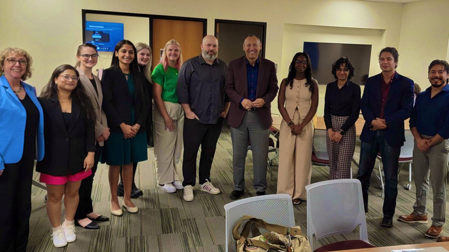 President Kelly Damphousse poses for a photo with a group of students from The Graduate College and leadership.