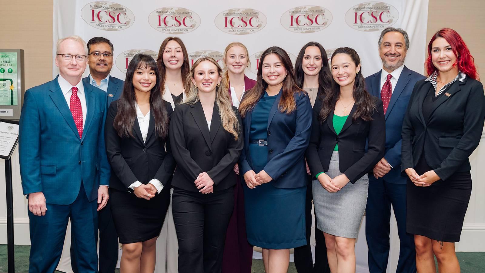 group of professionally dressed individuals posing for photo