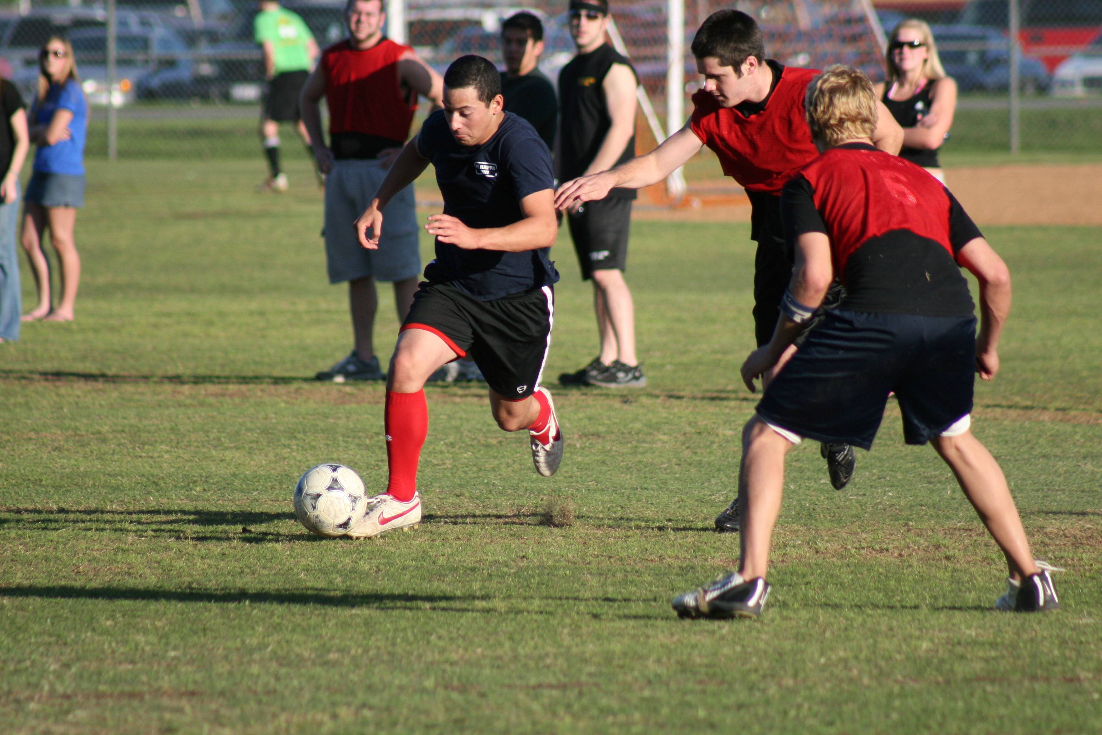 soccer player with ball is approaching a defender while playing outdoor soccer