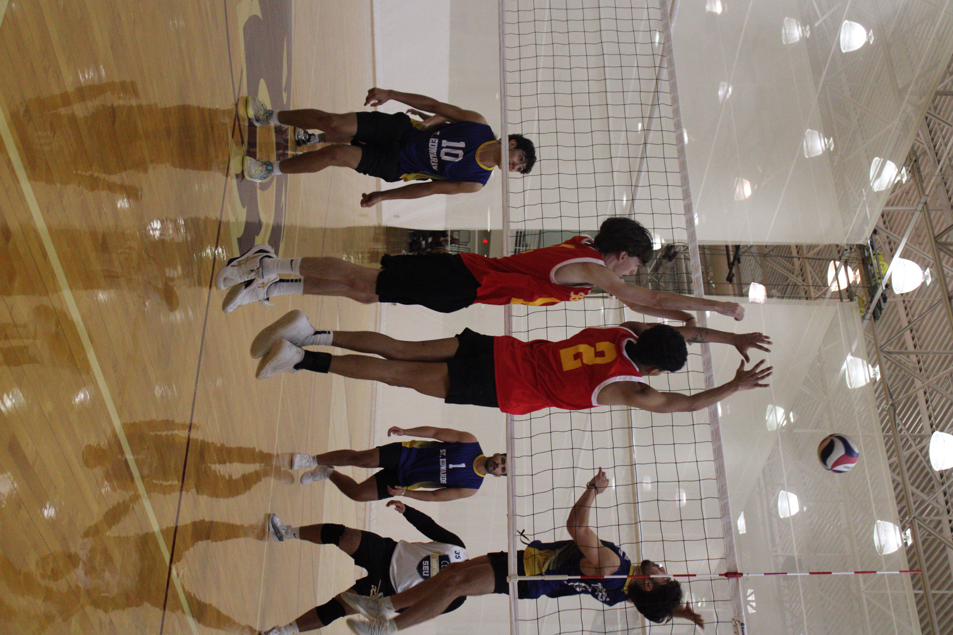 2 intramural participants blocking a volleyball spike
