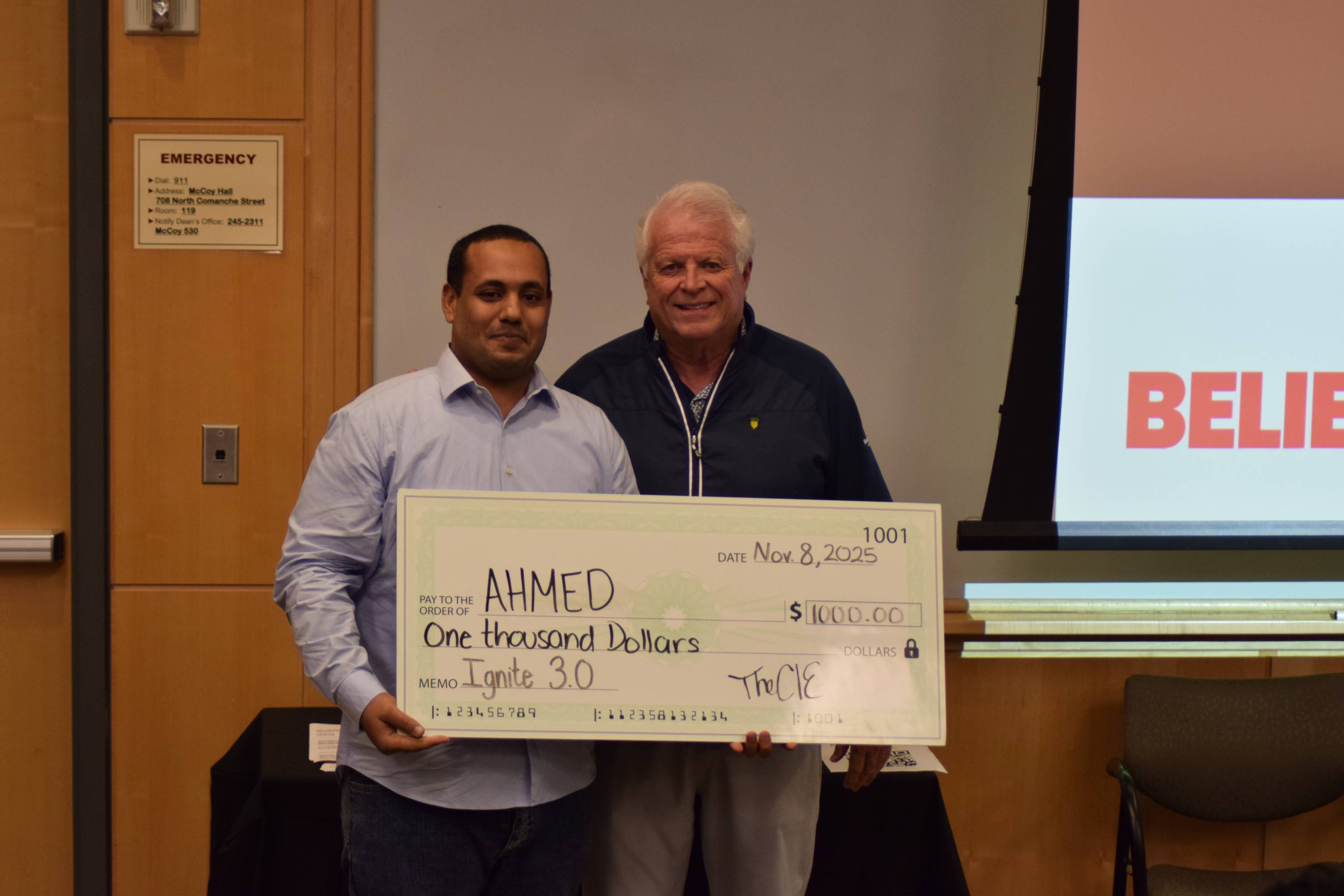 Ahmed posing with a judge after being awarded first place at the Ignite 3.0 pitch competition.