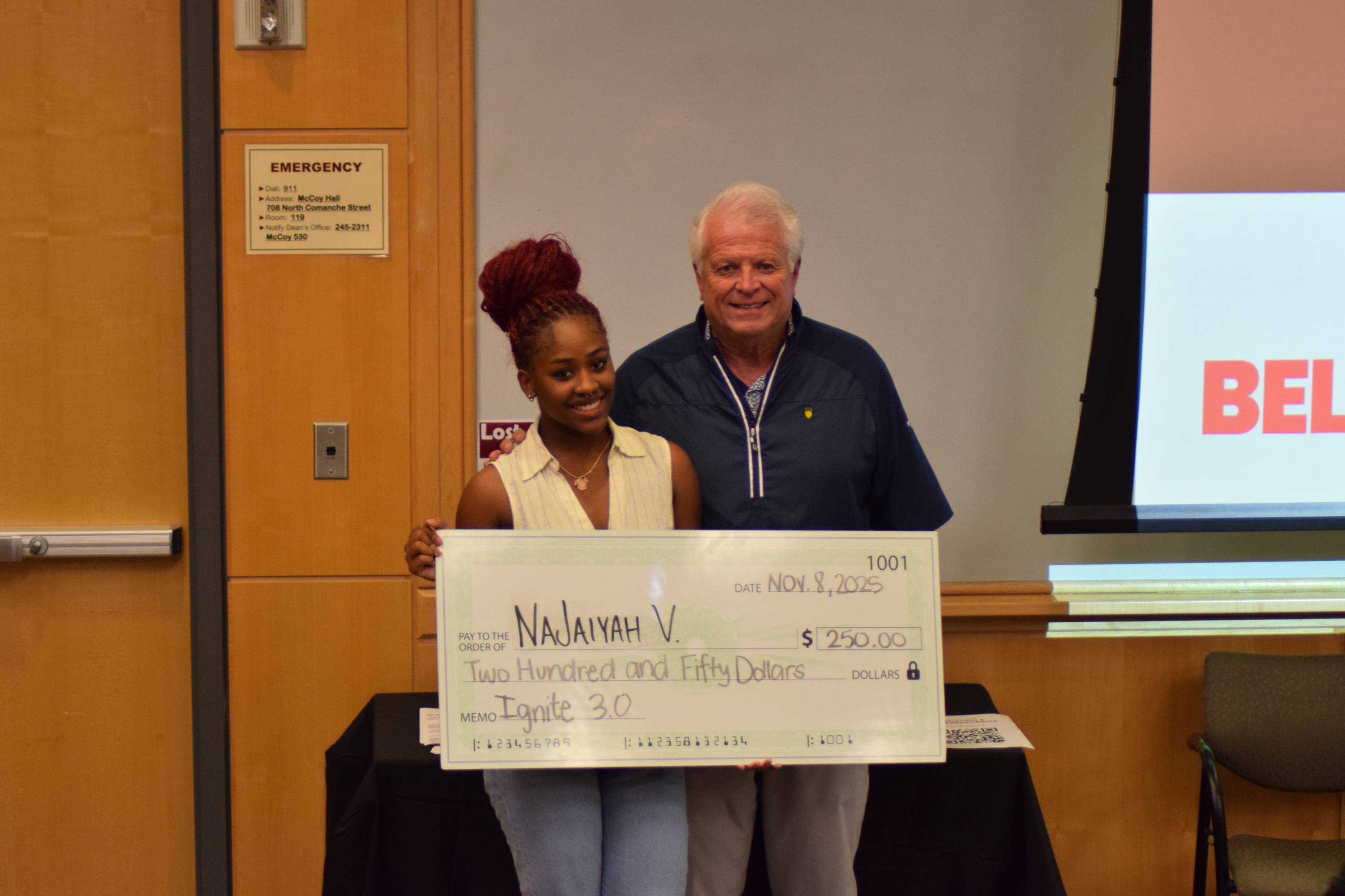 NaJaiyah Virgil posing with a judge after being awarded third place at the Ignite 3.0 pitch competition.