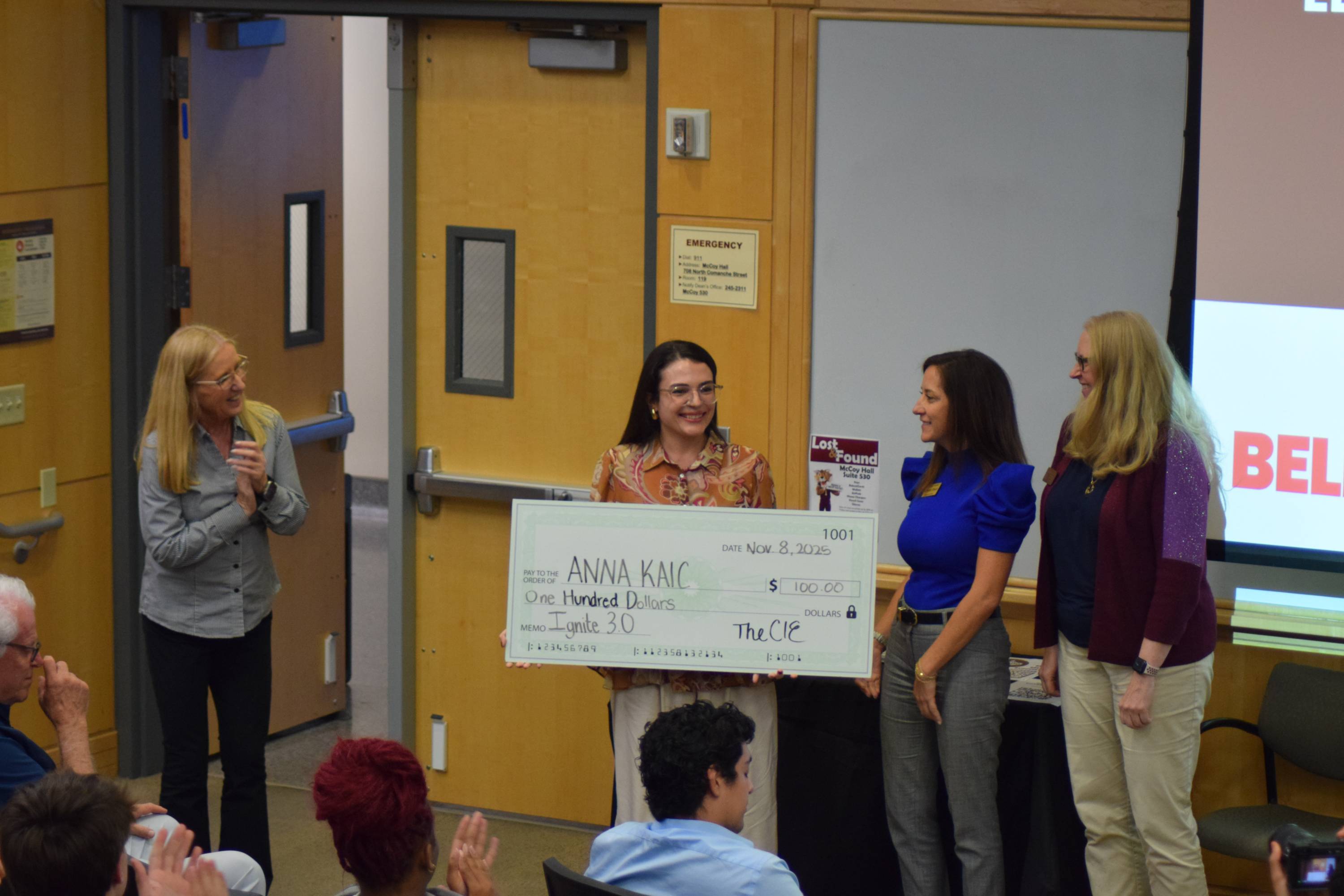 Anna Kaic accepts a check after winning both third place and People's Choice at Ignite 3.0.