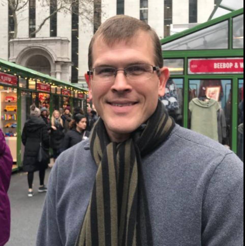 a picture of a man in a market square wearing a scarf