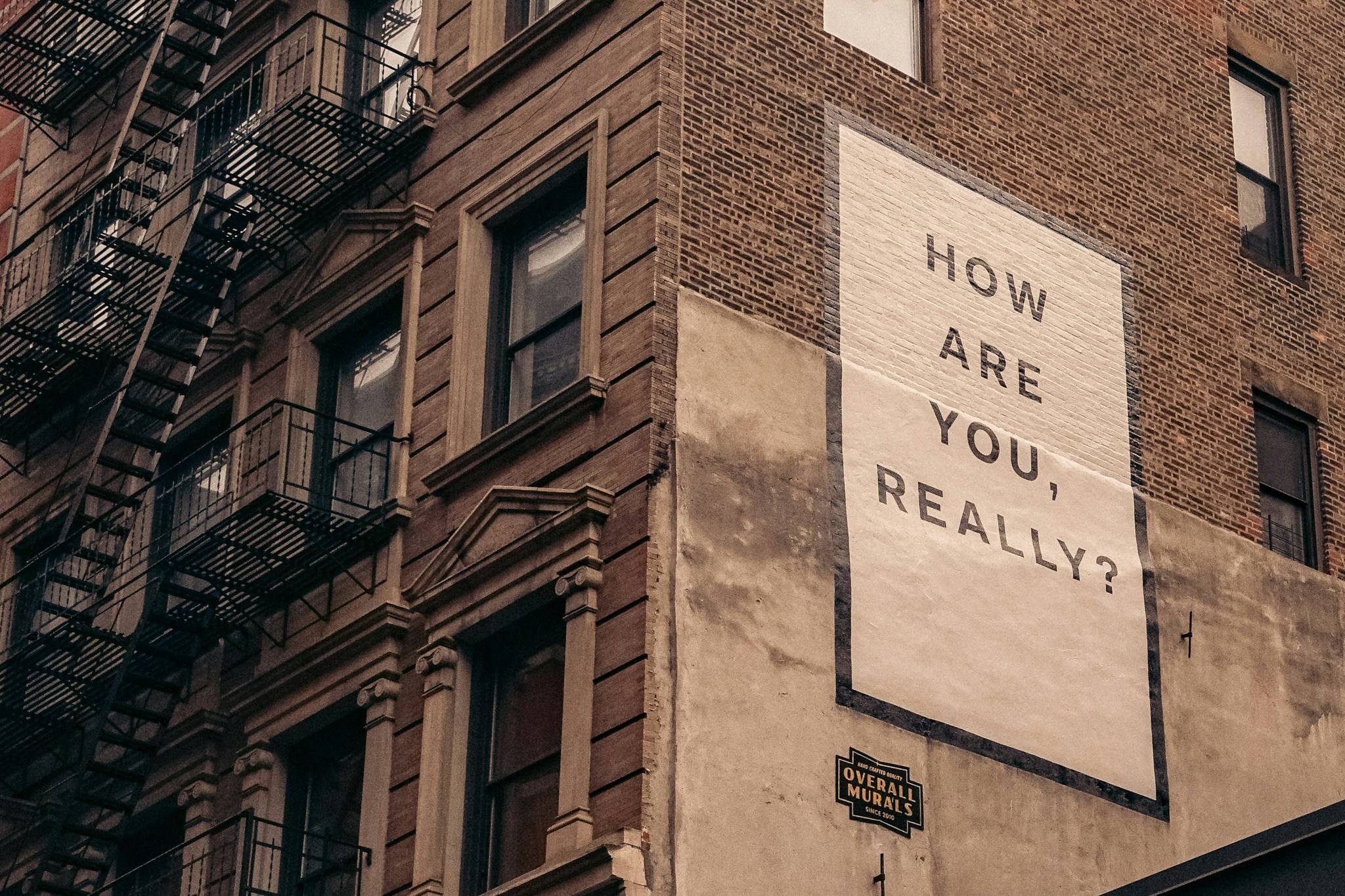 Sign on the side of a building that reads "How are you really?"