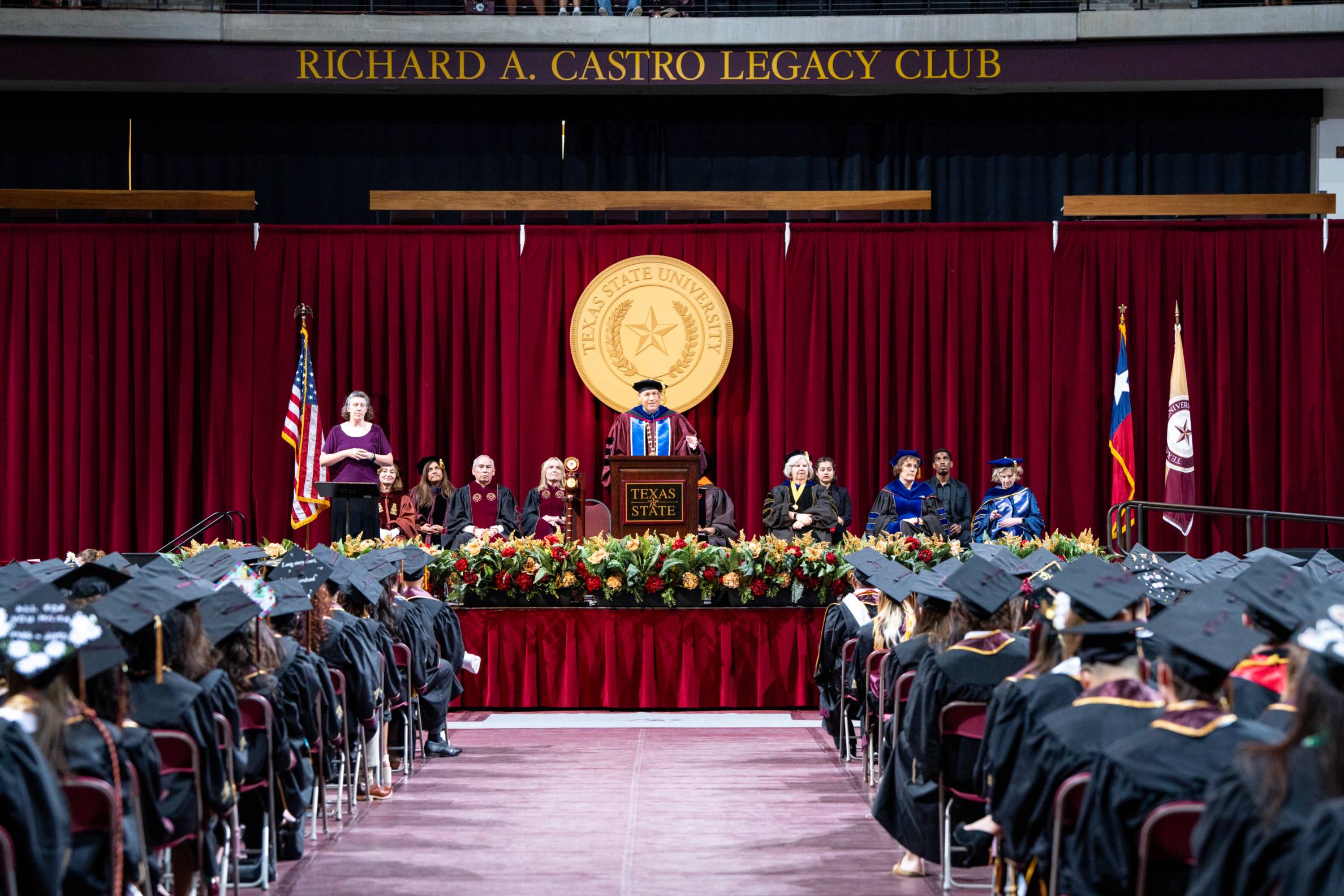 view of commencement ceremony with president damphousse giving speech at podium