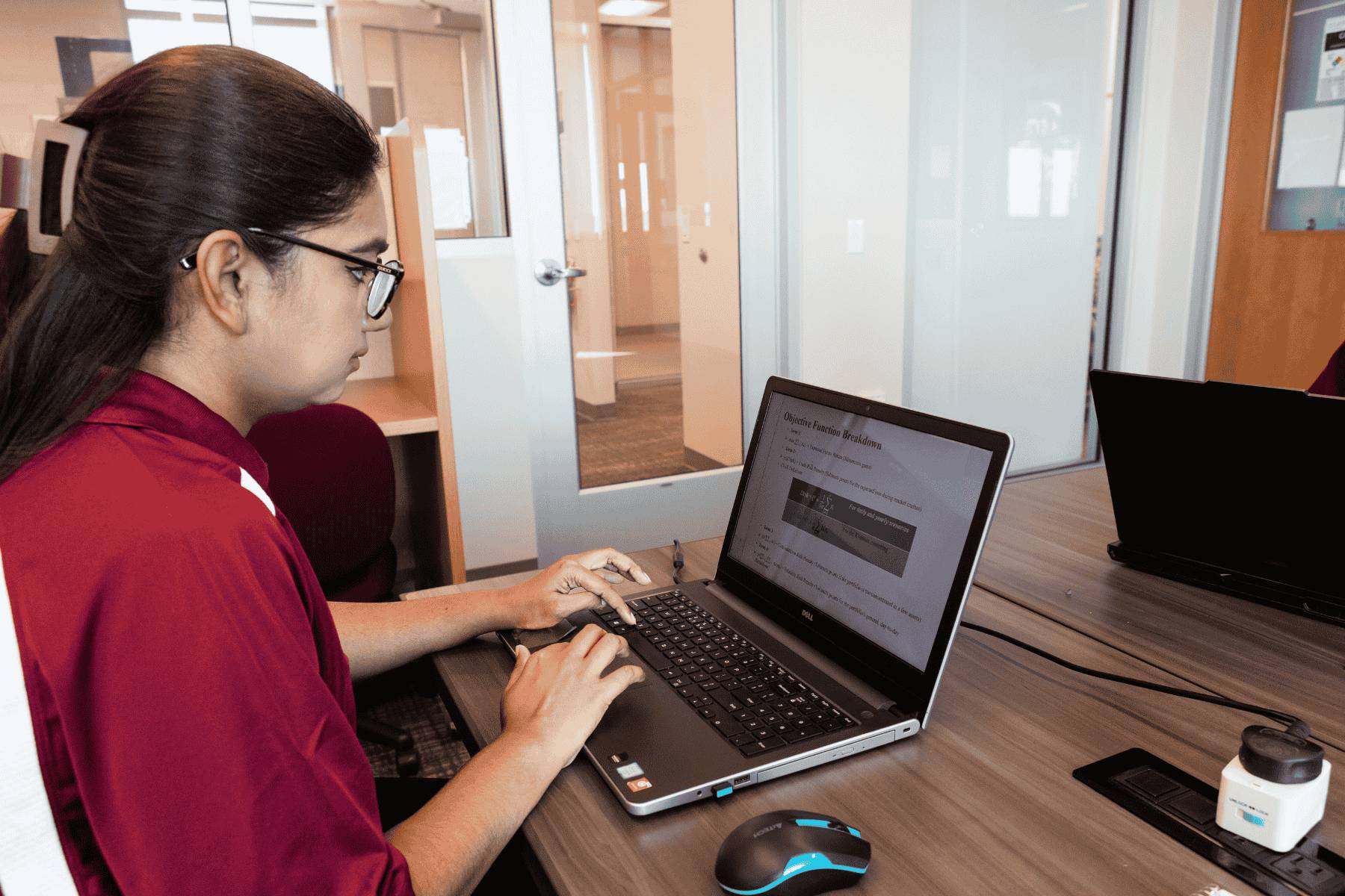 A student sitting at a desk and working on a computer