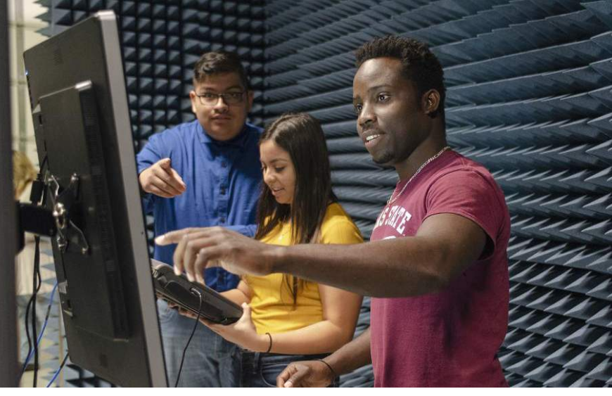 Three students doing research on computer