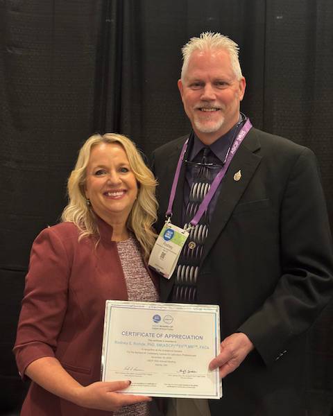 Amy Spiczk (left) and Rodney Rohde pose for a photo with a certificate of appreciation.