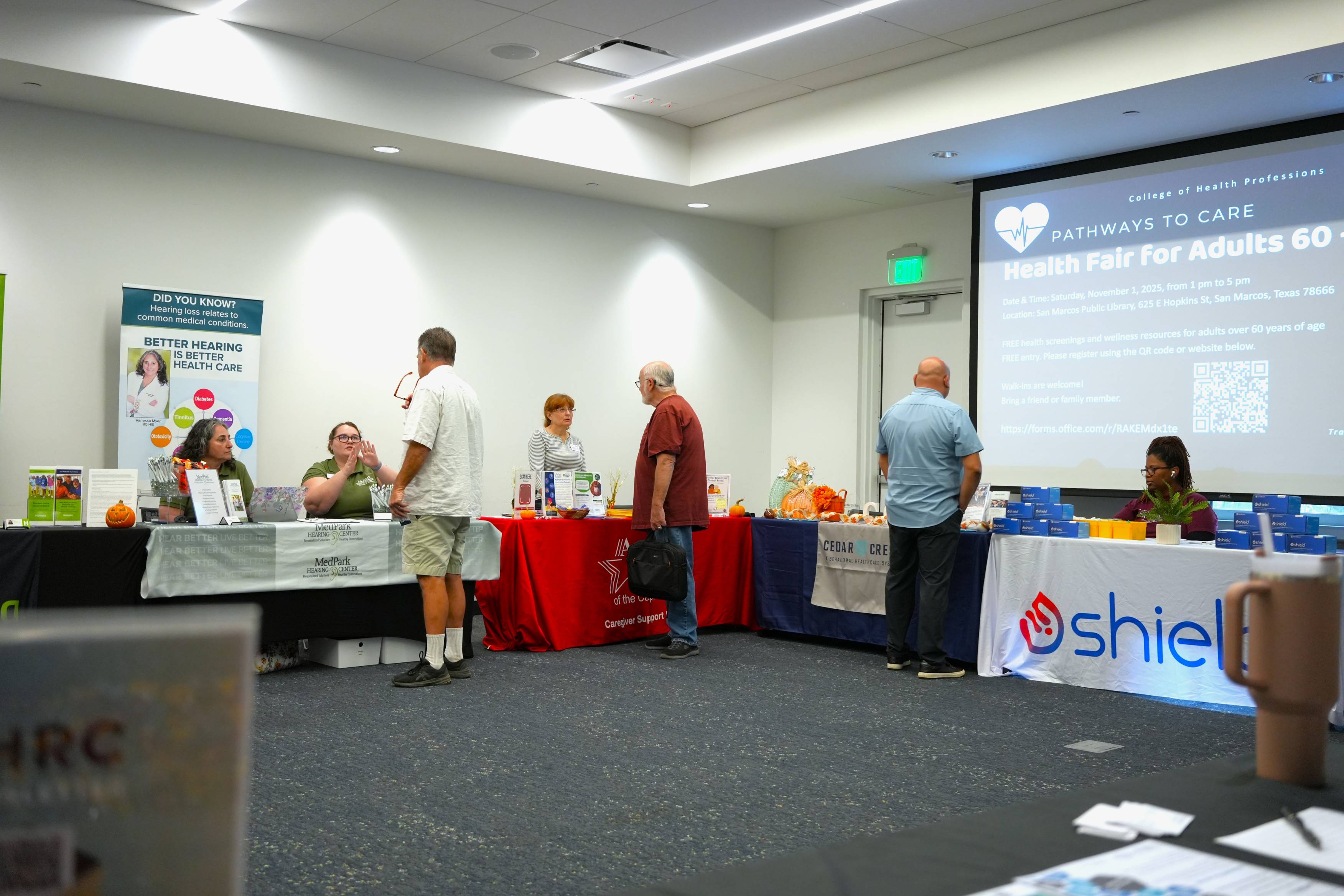 Attendees at the Pathways to Care Health Fair visit at booths for local healthcare organizations