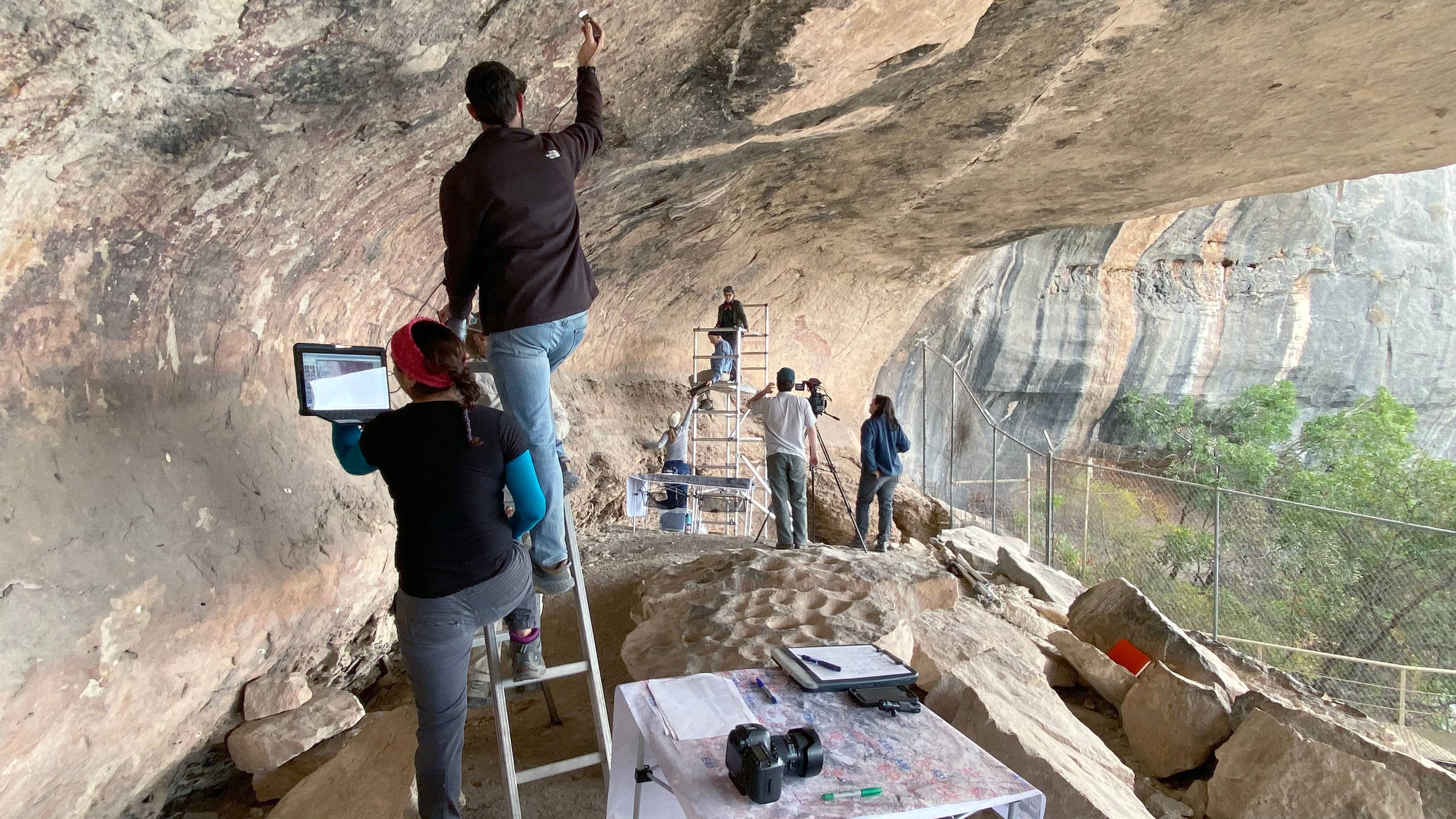 researchers looking at rock art on pecos river rocks