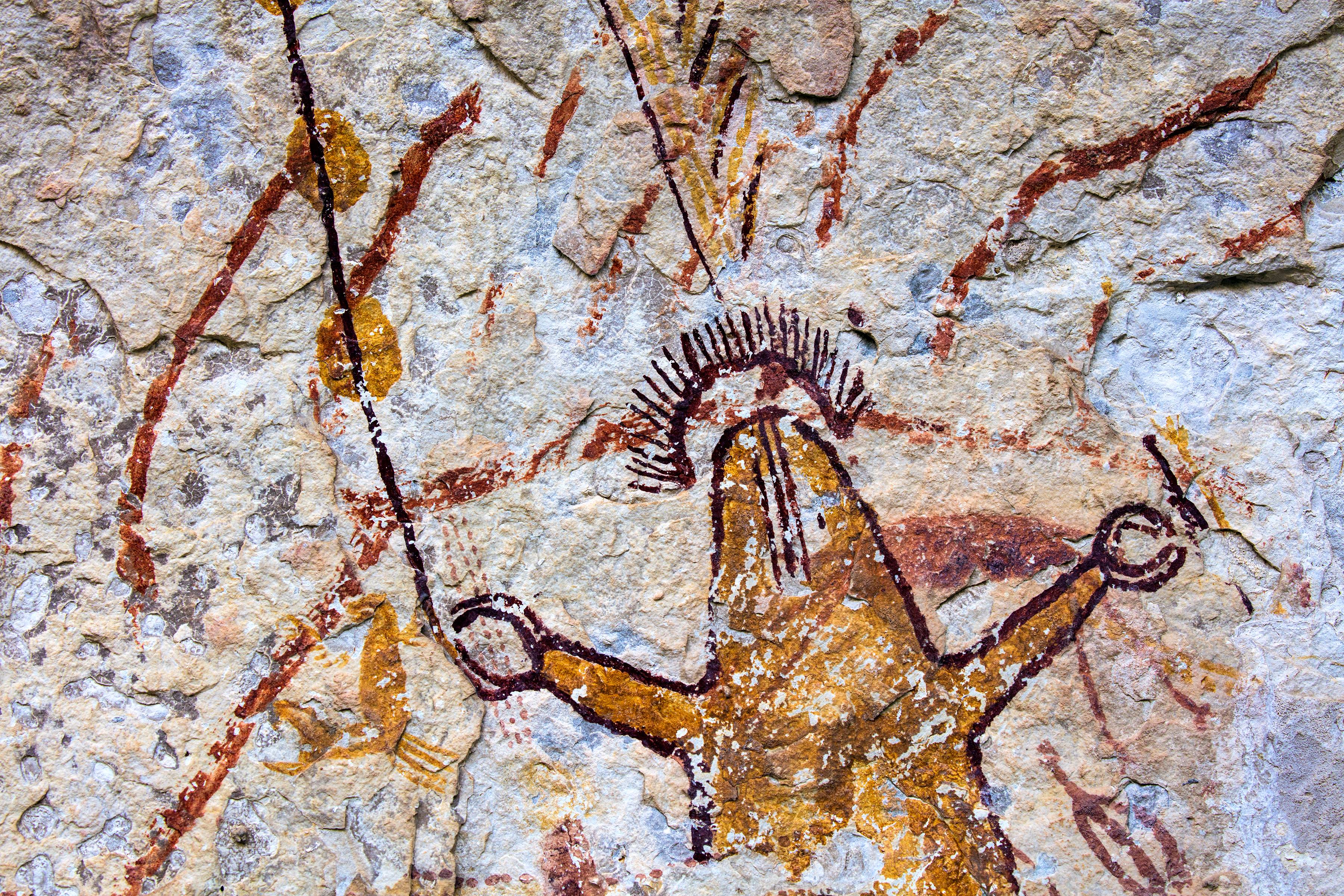 6000 year old rock painting of man with arms up on pecos river rocks 