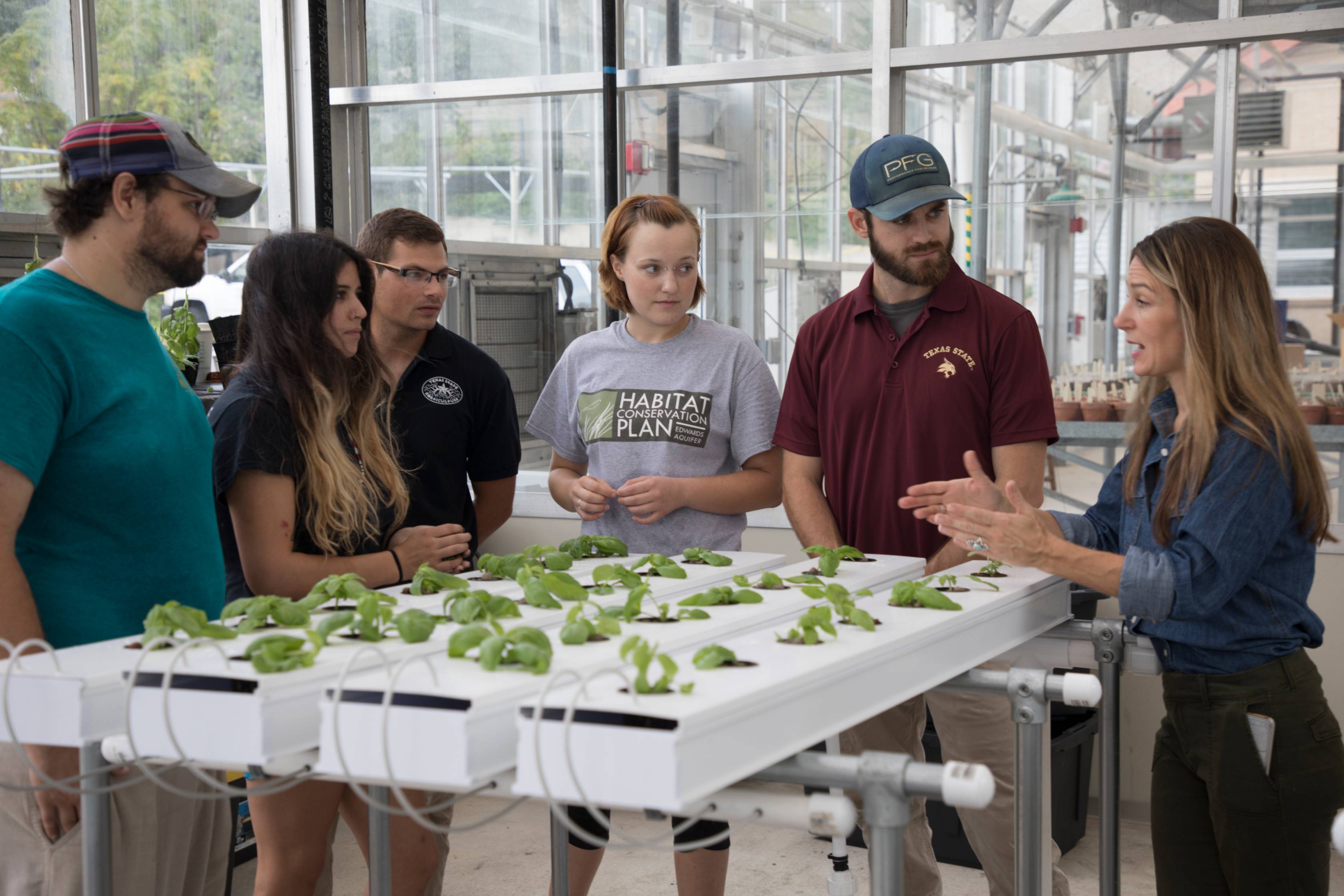 students and instructor in greenhouse