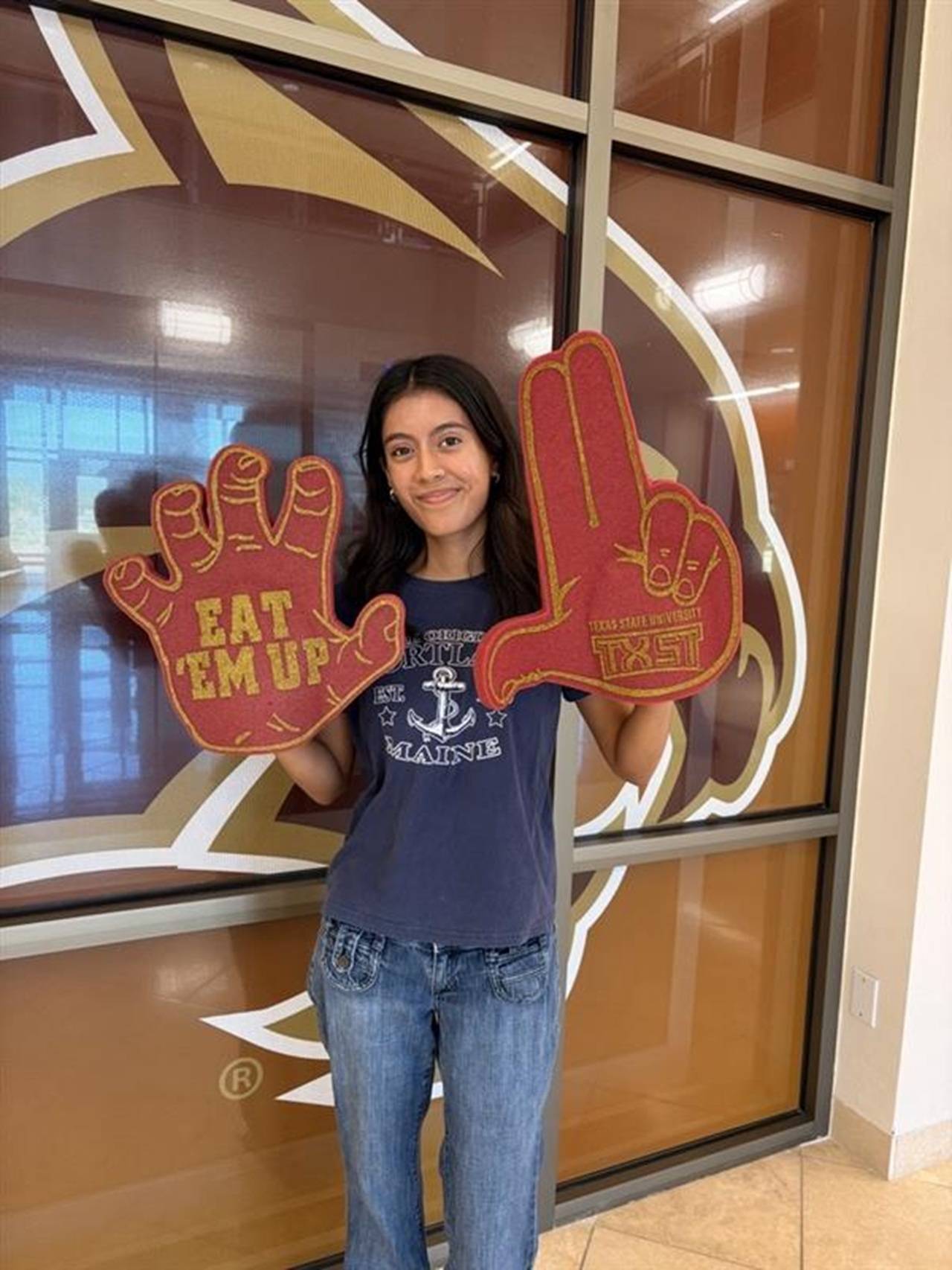 a student holding foam fingers
