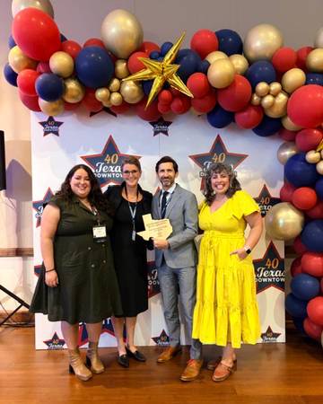 TXST Honors College faculty pose for a photo with an award.