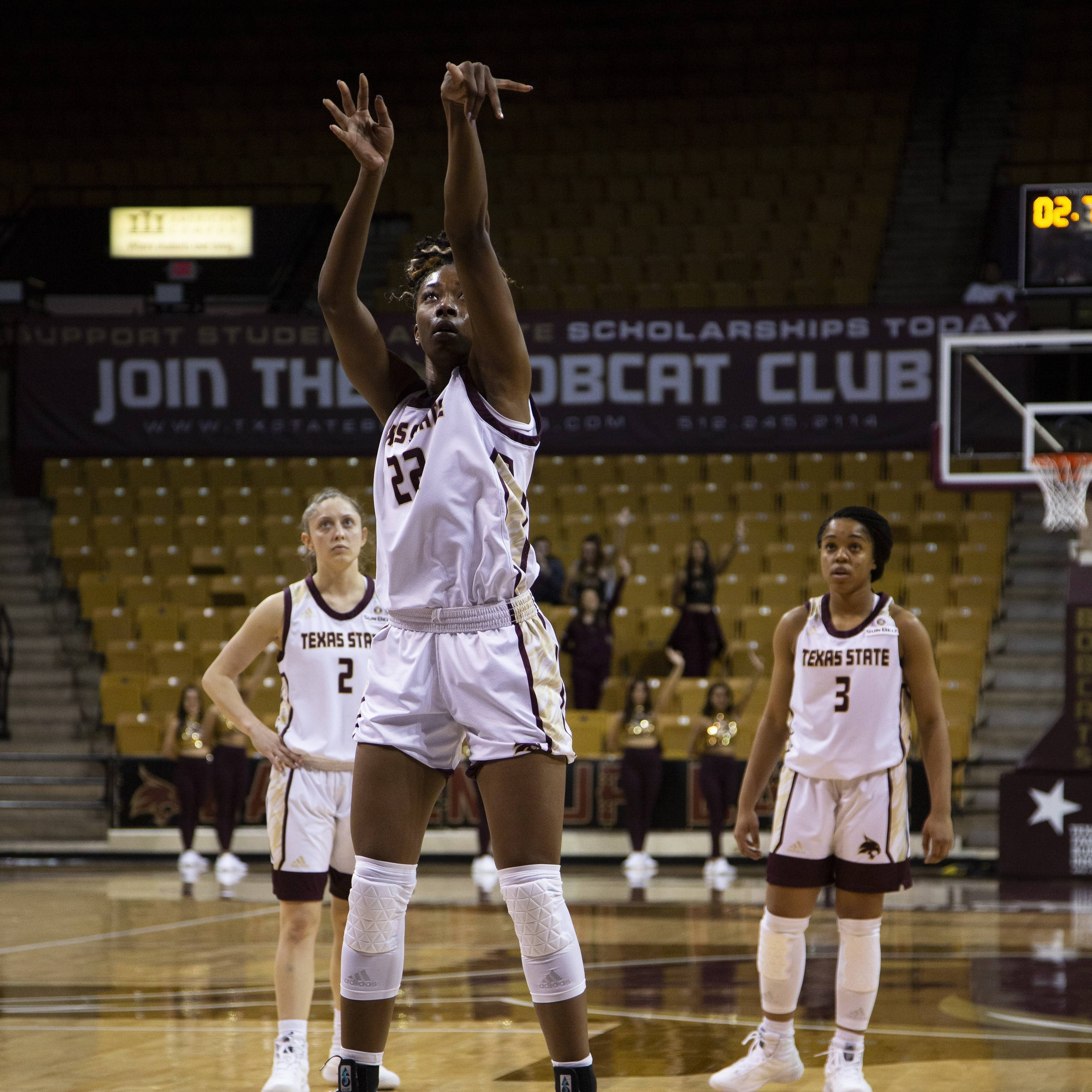 a student shooting the basketball on the womens basketball team