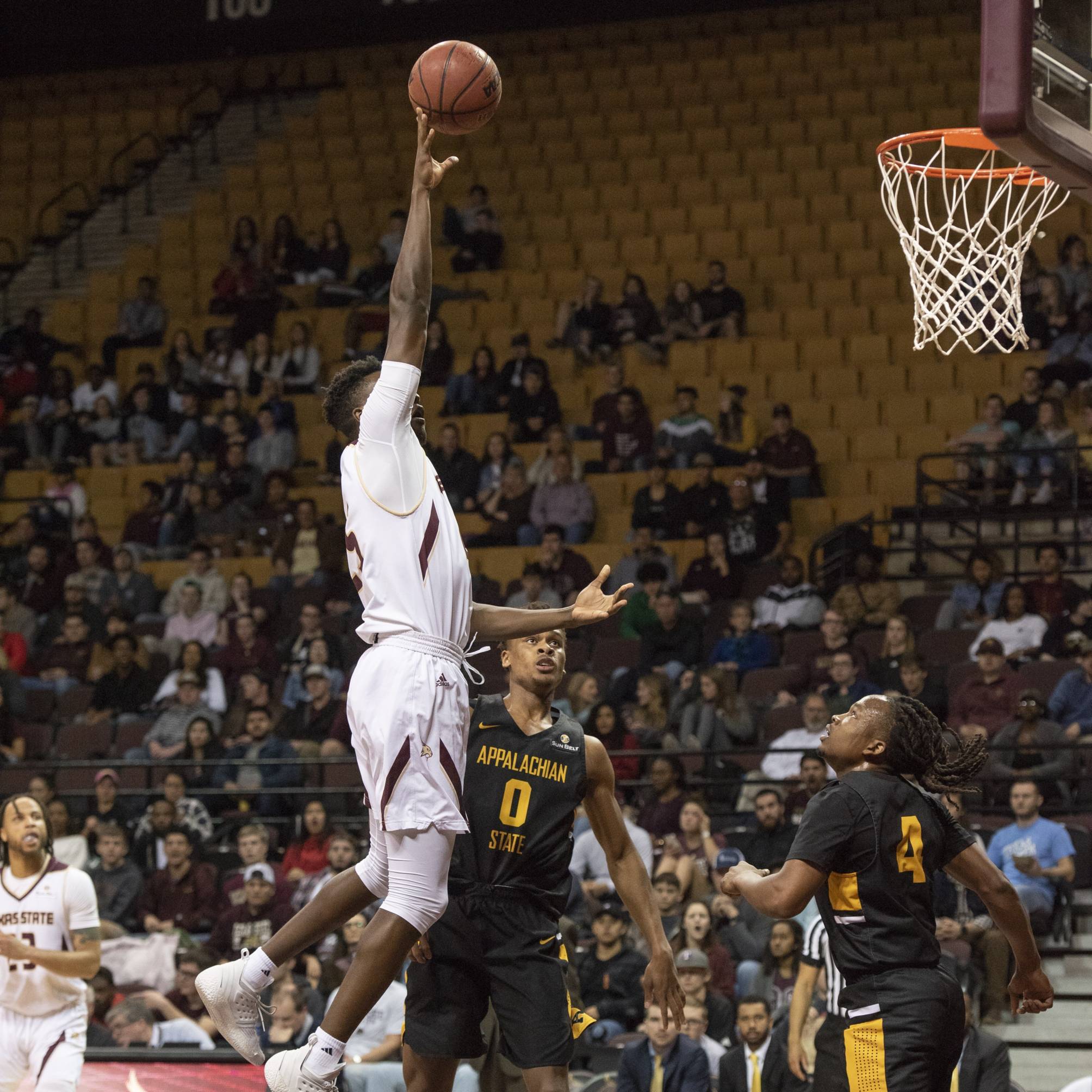 a student shooting a basketball into the basket