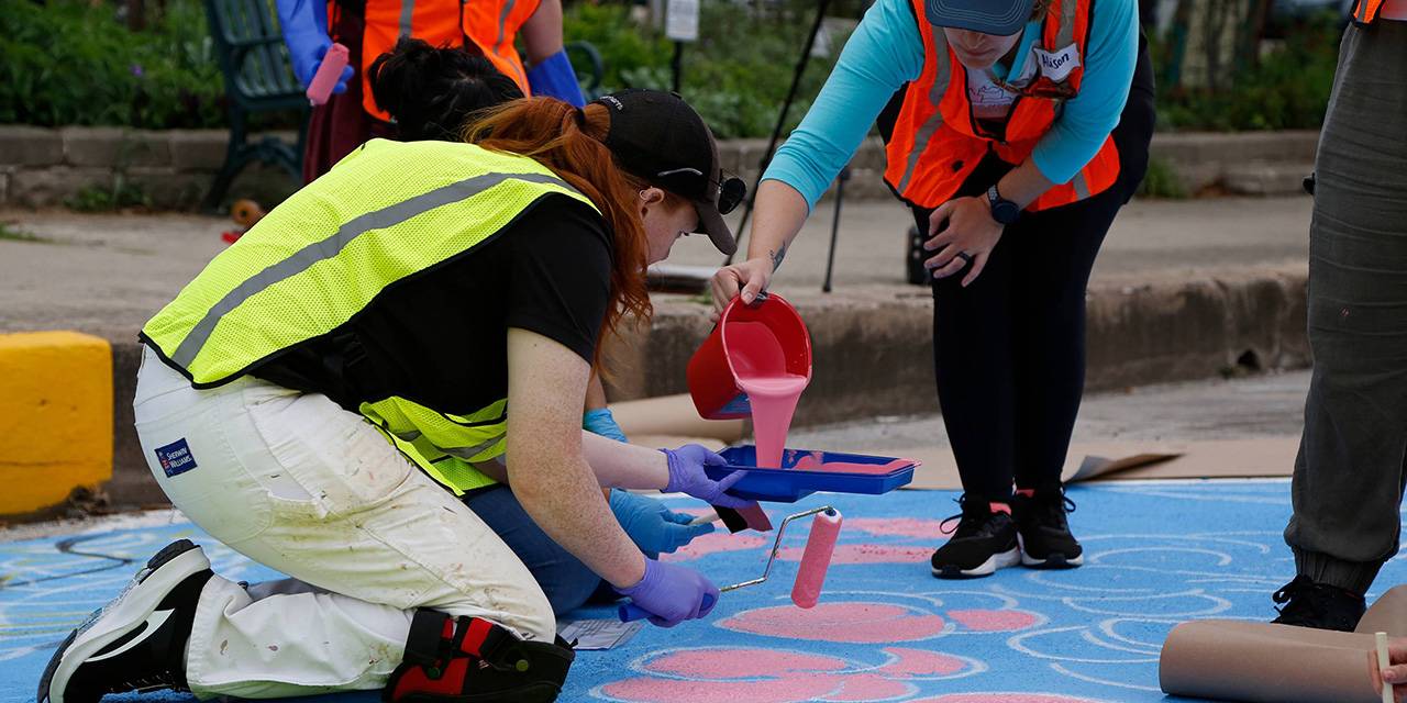 TXST Honors College students and community members paint a street mural.