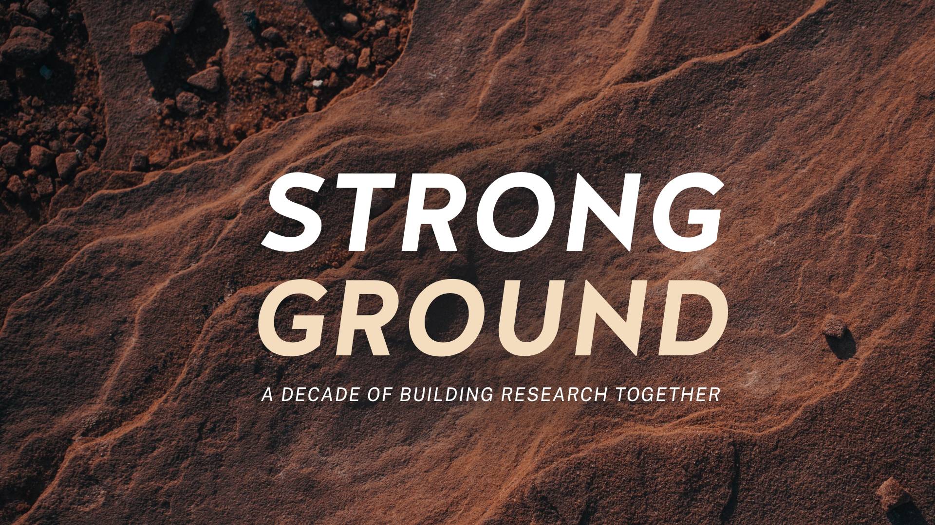 Image of reddish brown soil. The text reads, "Strong Ground: Strong Ground Isn’t Found—It’s Built Together."
