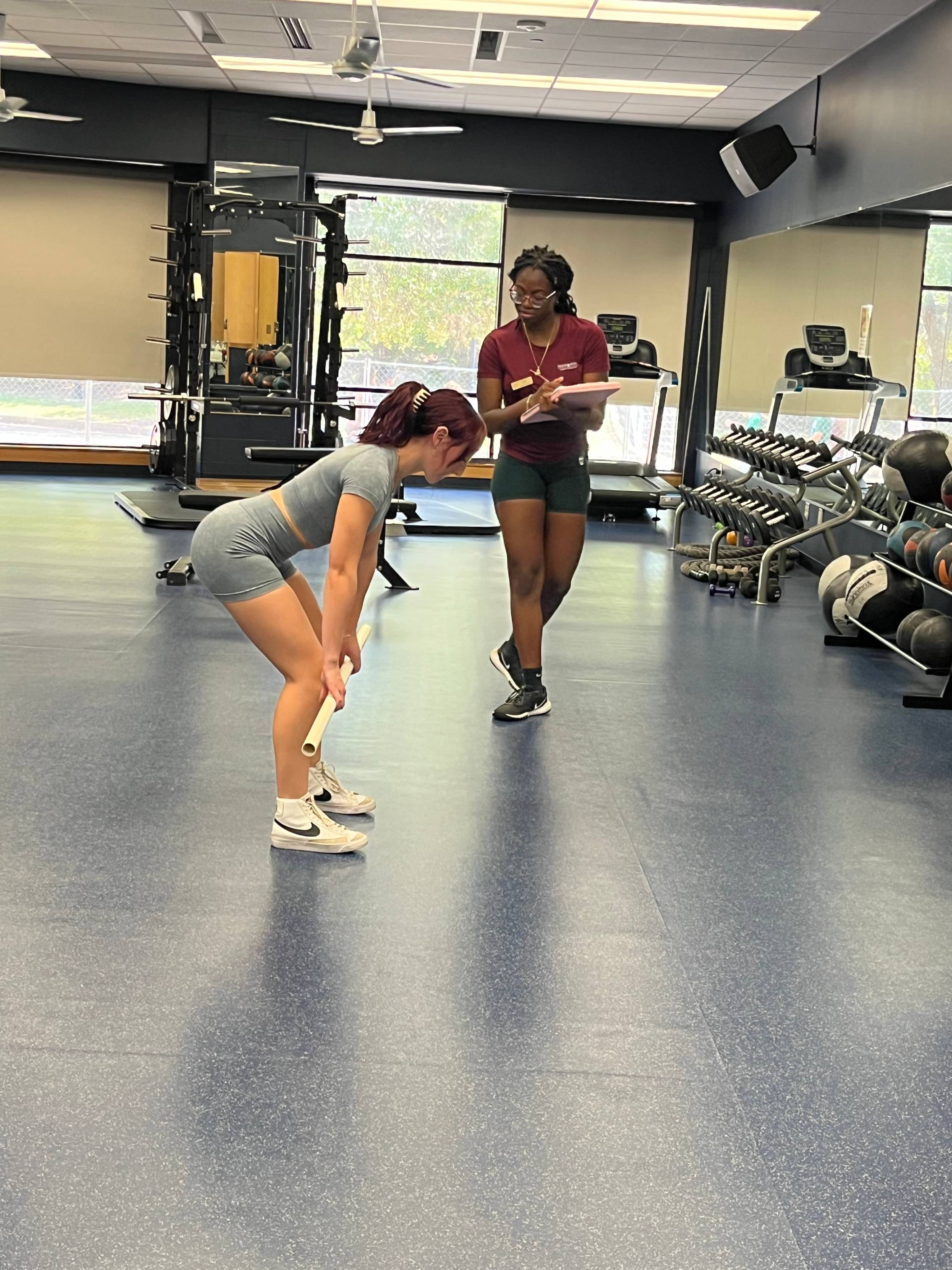 A trainer helping a student workout