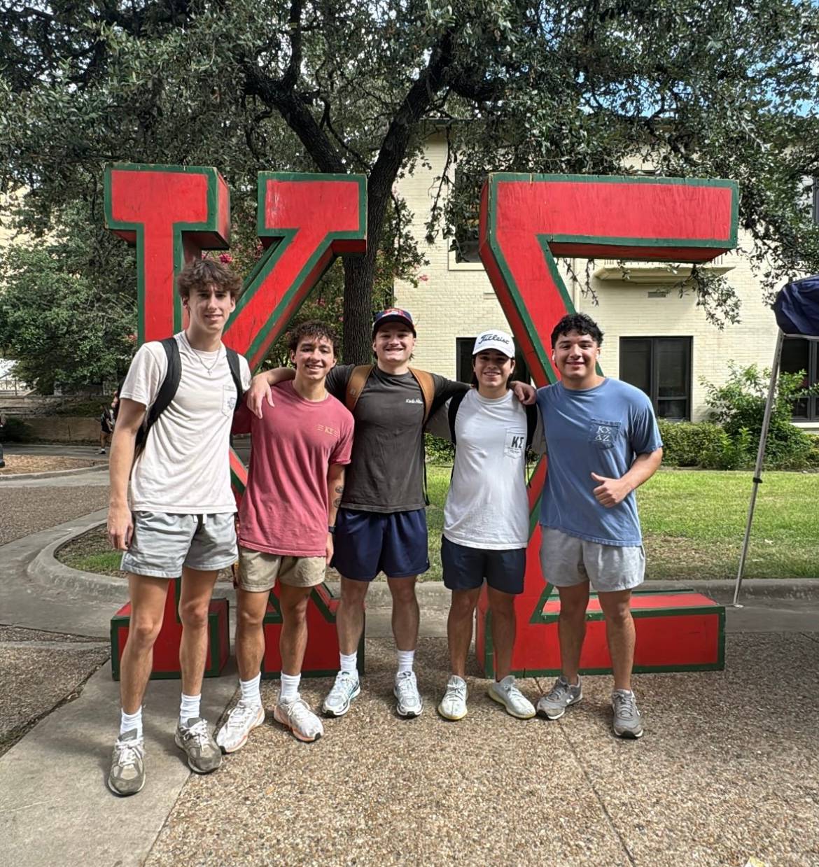 students on the quad standing in front of letters