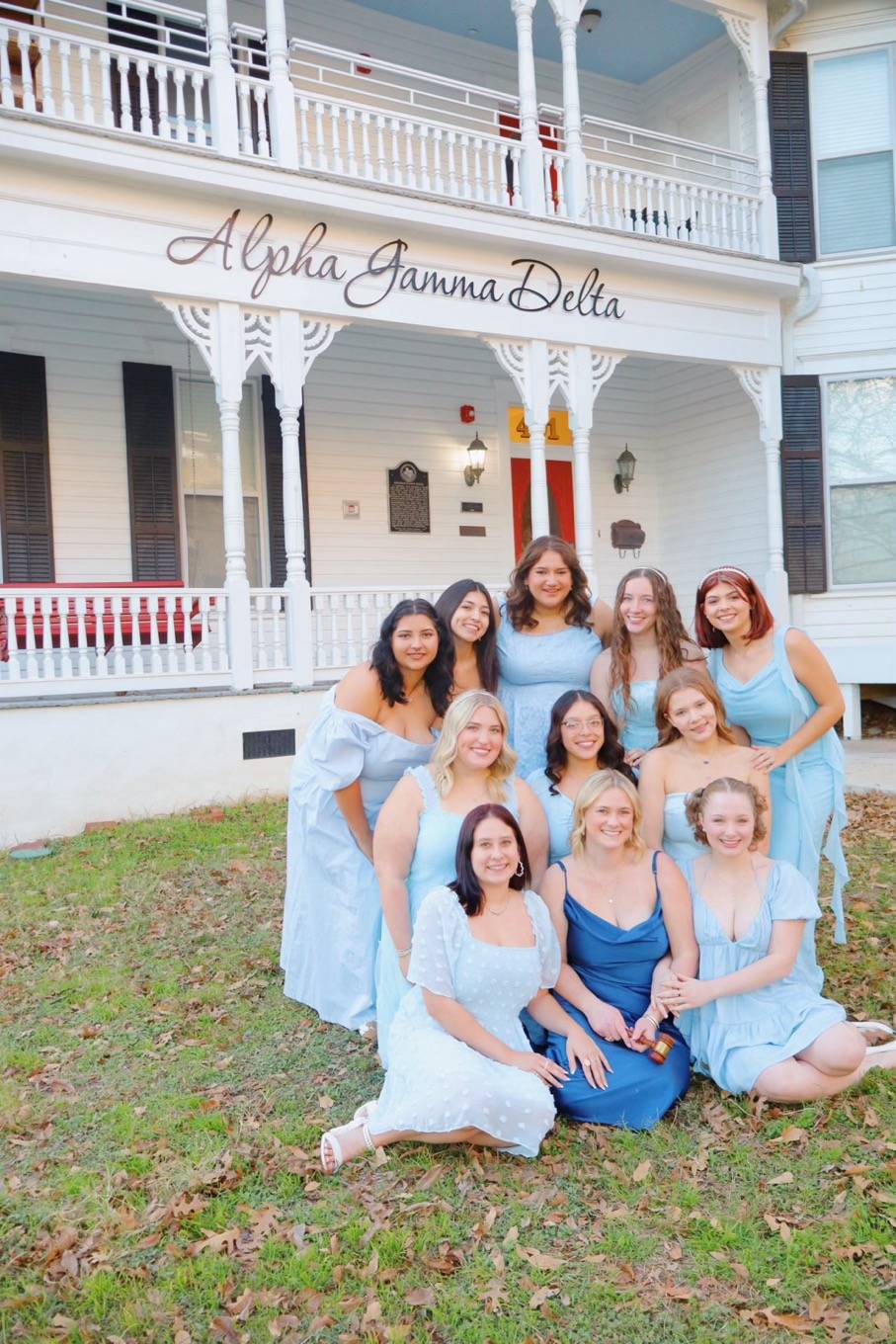 Women posing in front of a house