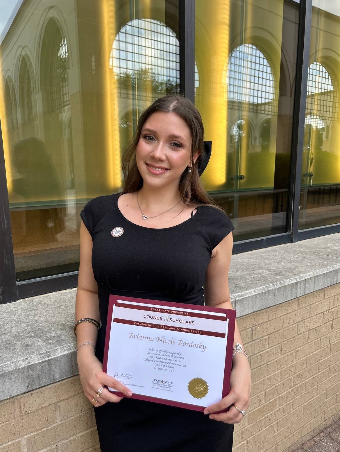 Student standing holding diploma 