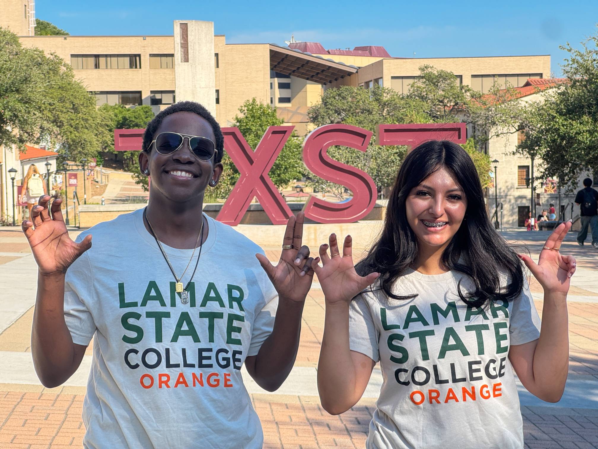Gateway Ambassadors holding up the Texas State University hand sign.