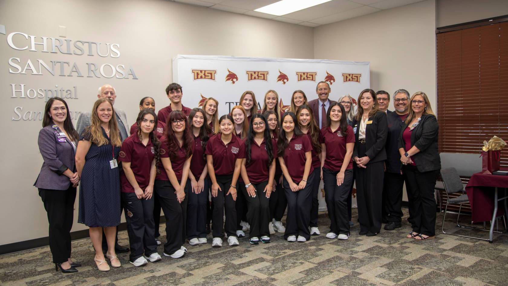 President Kelly Damphousse poses for a photo with TXST nursing students and CHRISTUS leadership,