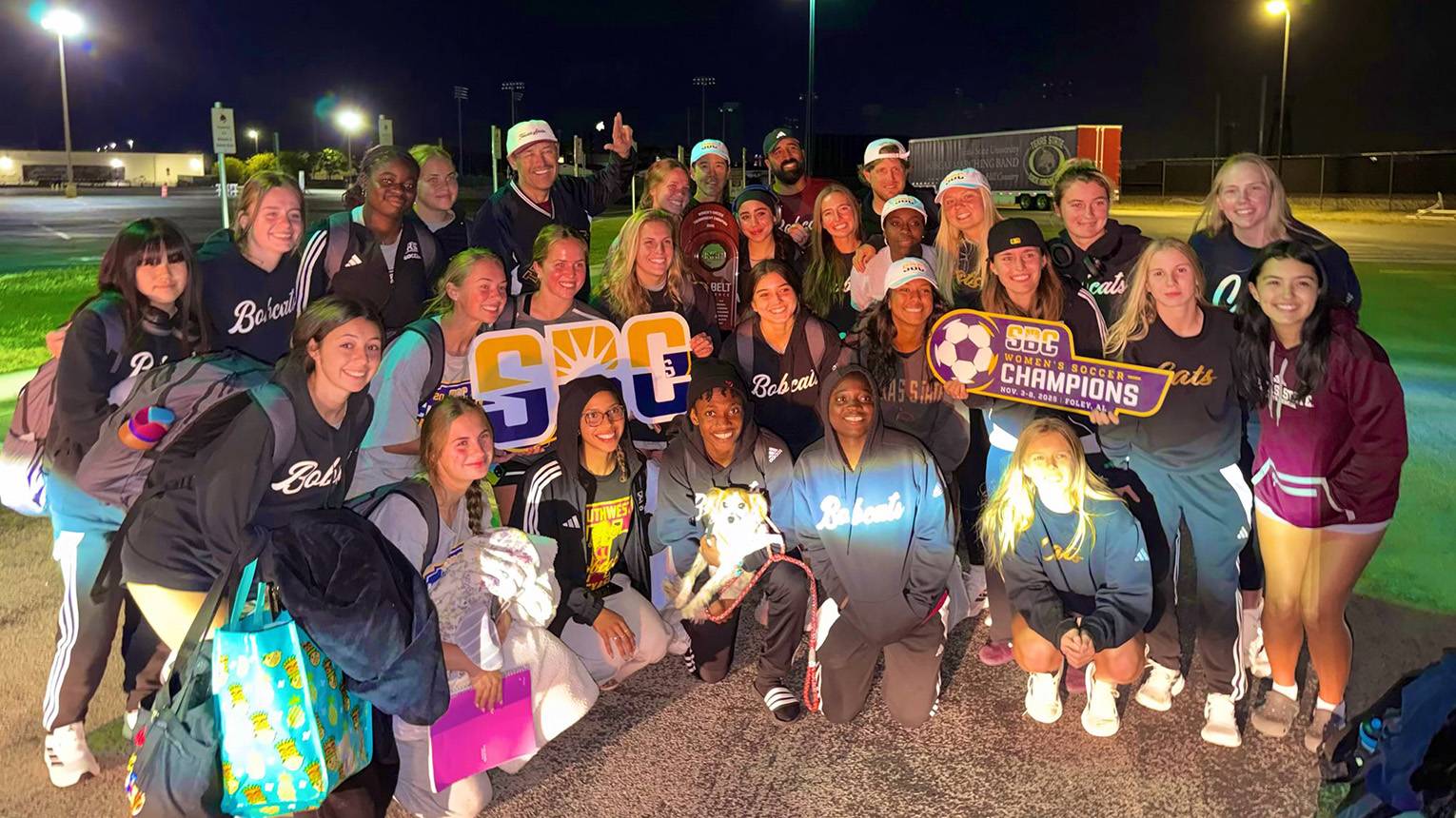 President Kelly Damphousse poses for a photo with the entire TXST Soccer team on the field.